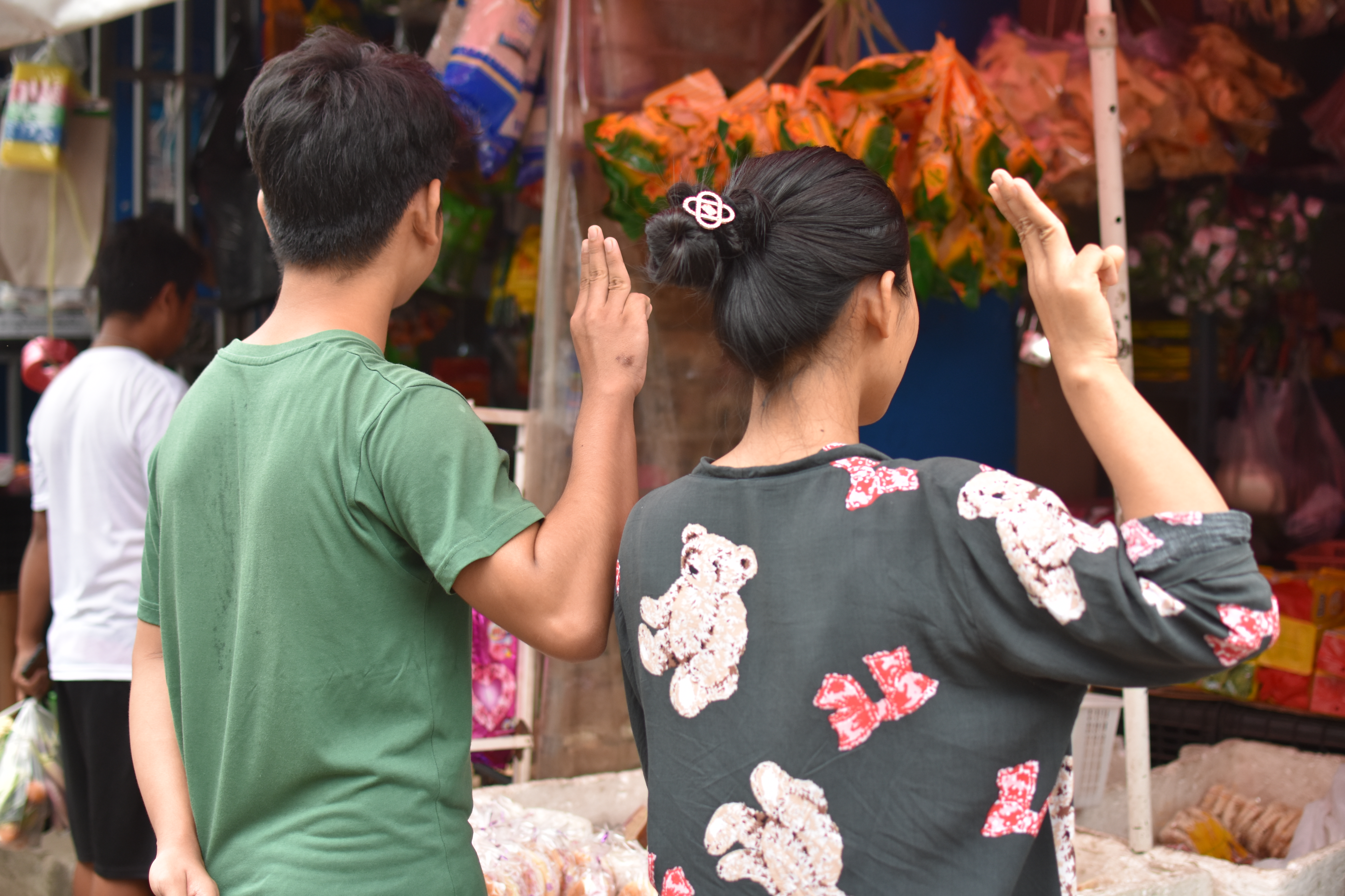 The young man and woman who bravely flashed the three-finger salute at the 10-mile market in Yangon, April 2, 2021