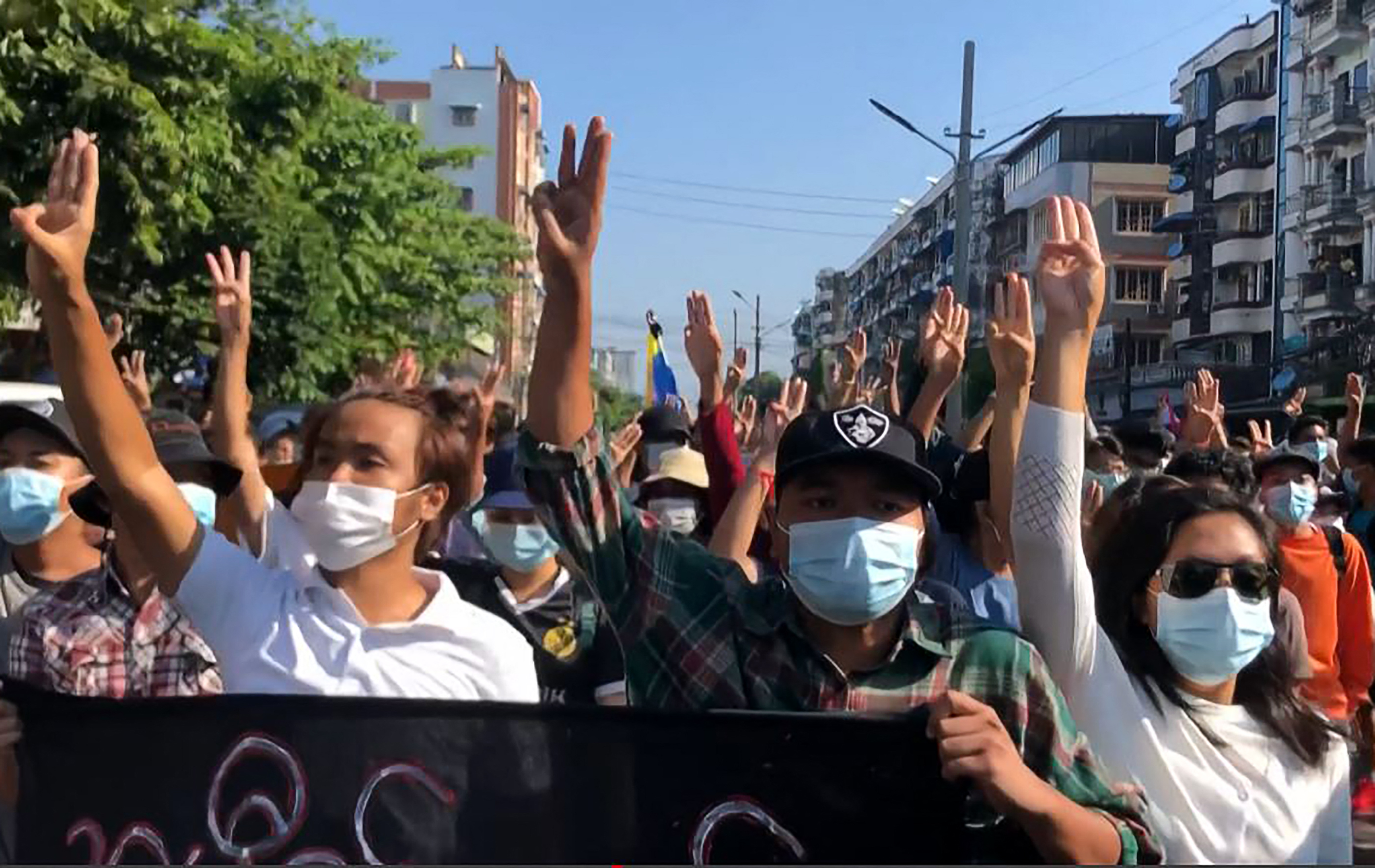 Protesters make the three-finger salute as they take part in a flash mob as part of demonstrations against the military coup on ‘Global Myanmar Spring Revolution Day’ in Yangon, Myanmar