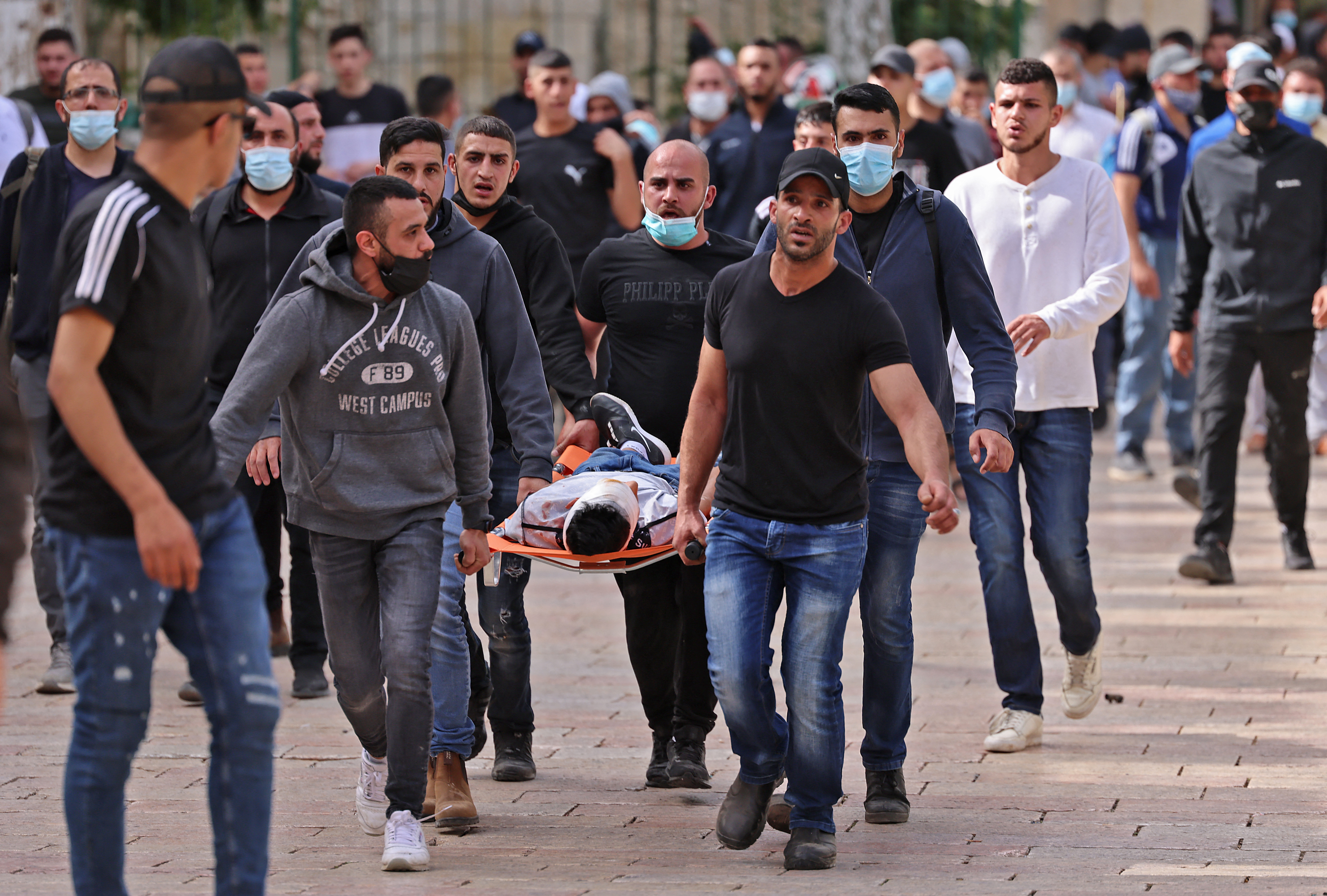 Palestinians evacuate a wounded protester amid clashes with Israeli forces at the Damascus Gate in Jerusalem’s Old City on May 10, 2021