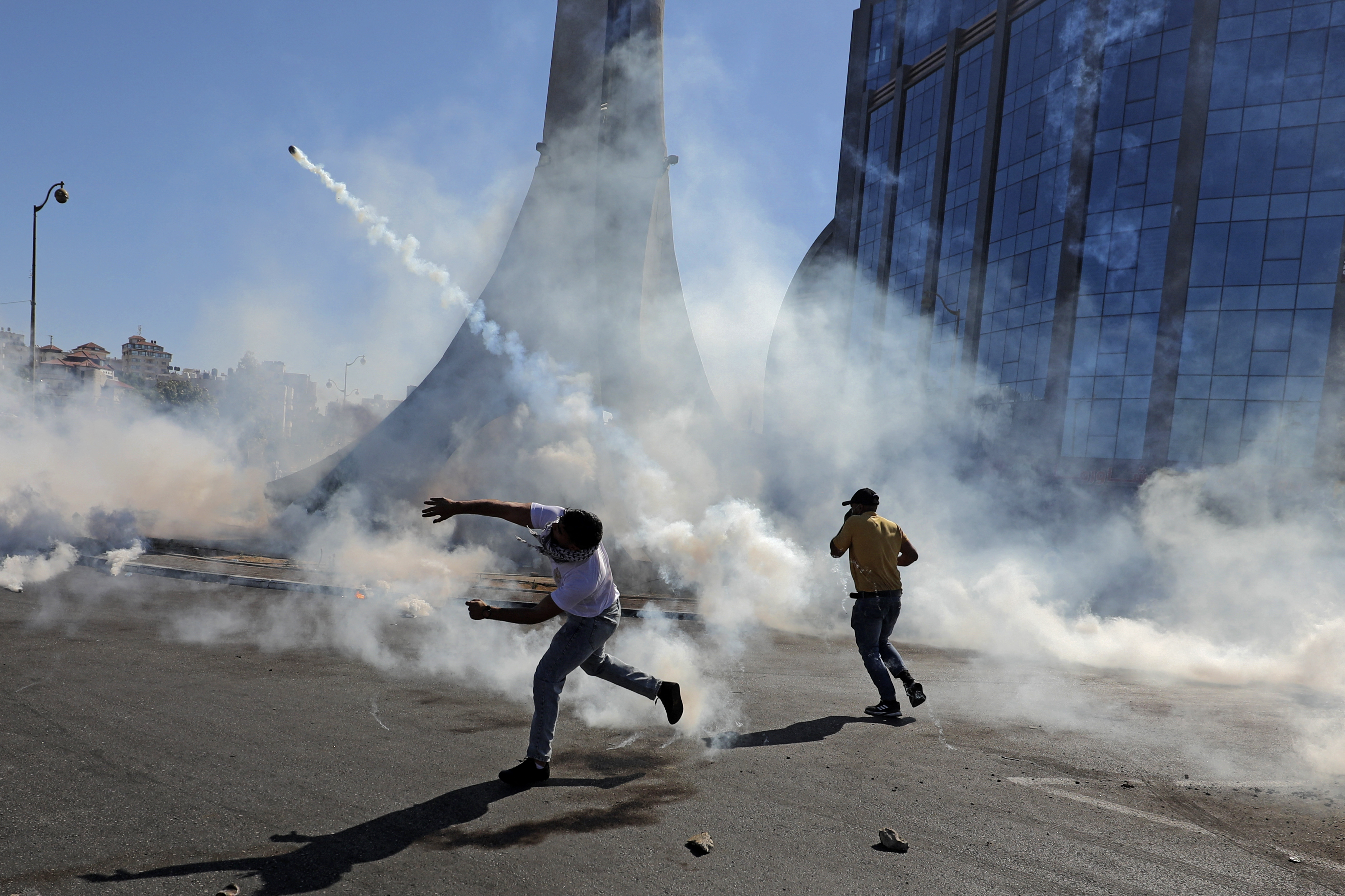 Palestinian demonstrators throw tear gas canisters back at Israeli forces during confrontations near the illegal Israeli settlement of Beit El near Ramallah in the occupied West Bank