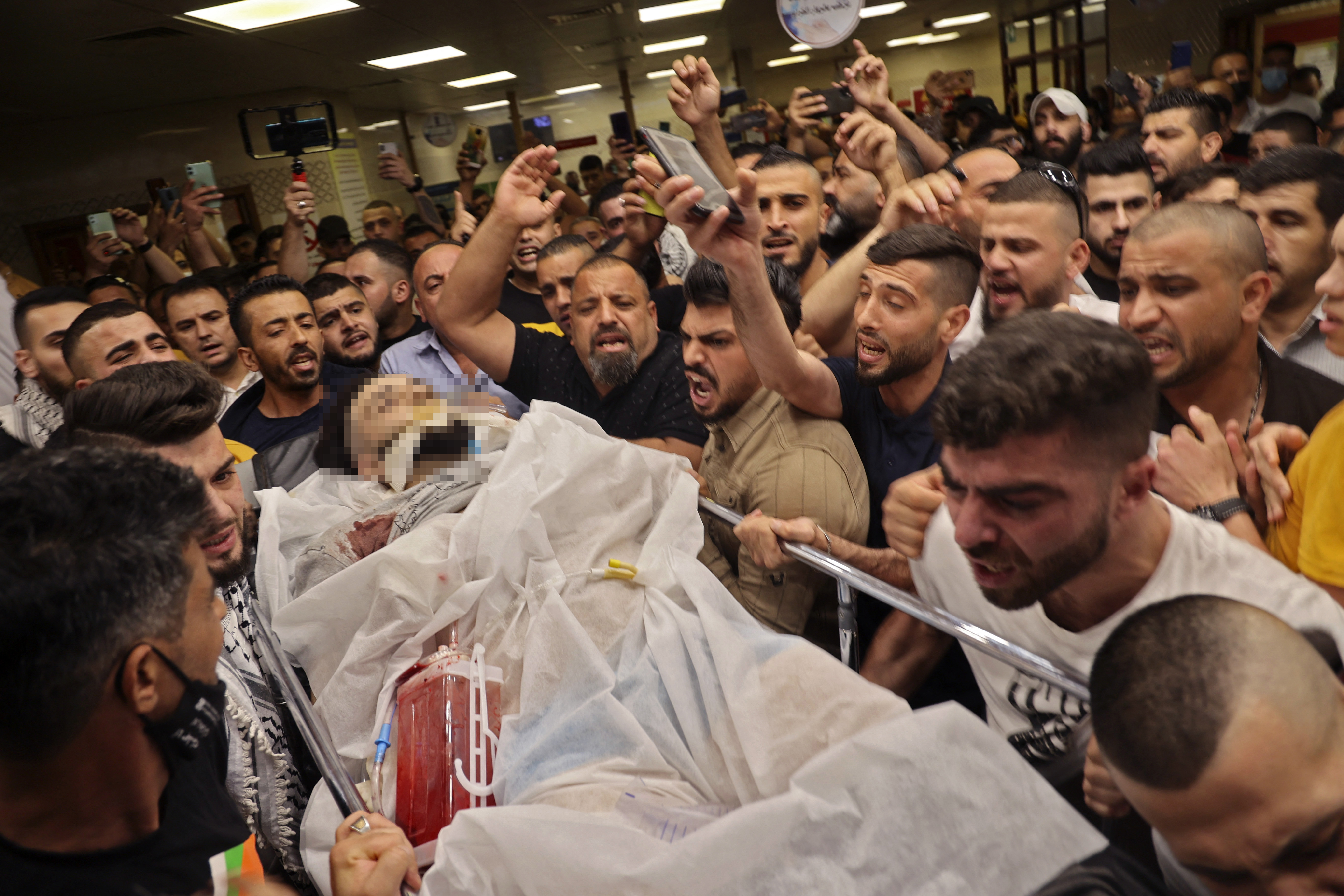 Palestinian mourners carry the body of 21-year-old Malek Hamdan, who was killed during clashes with Israeli forces in the village of Salem, during his funeral in the West Bank city of Nablus on Friday