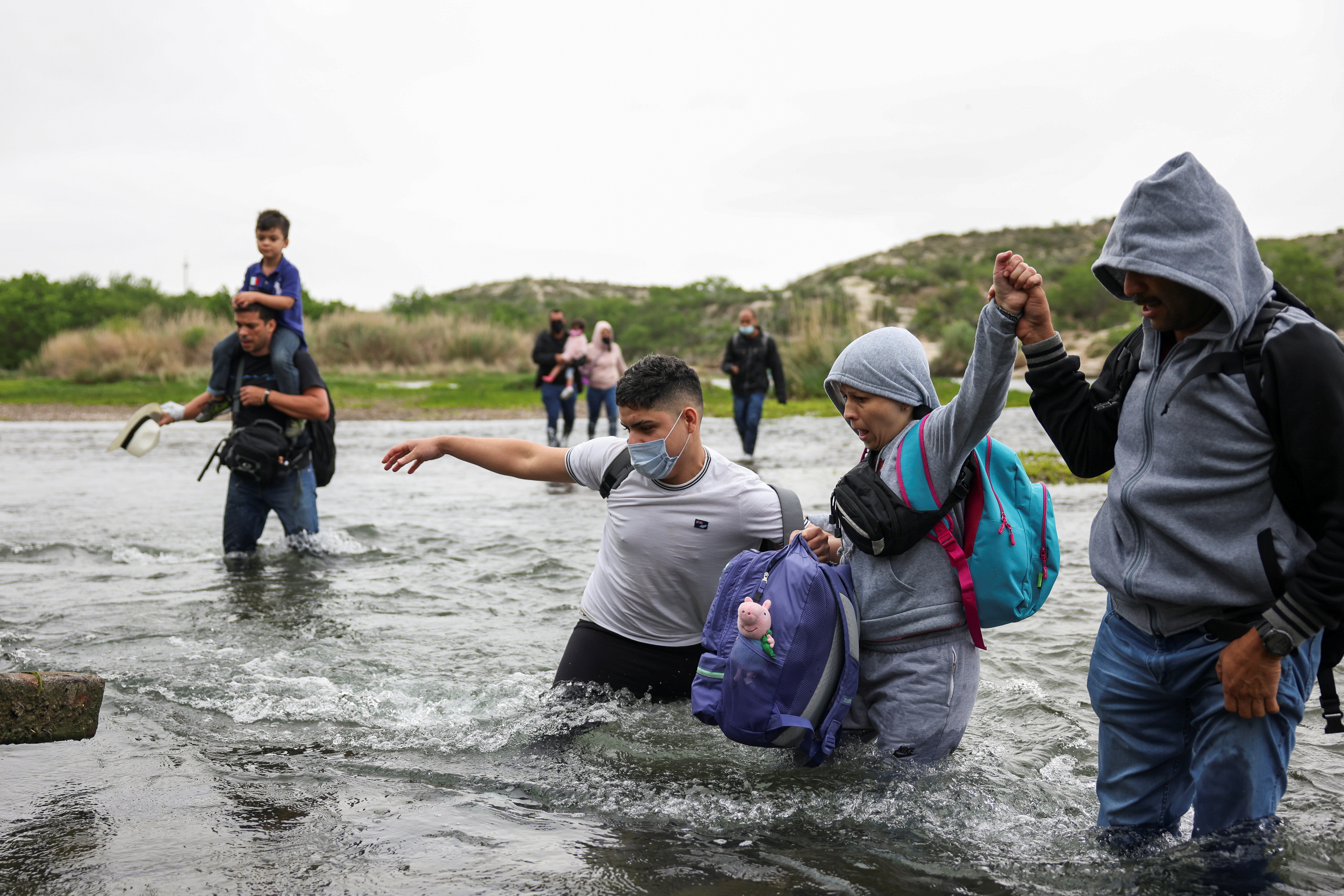Migrants cross the Rio Grande River into the US from Mexico