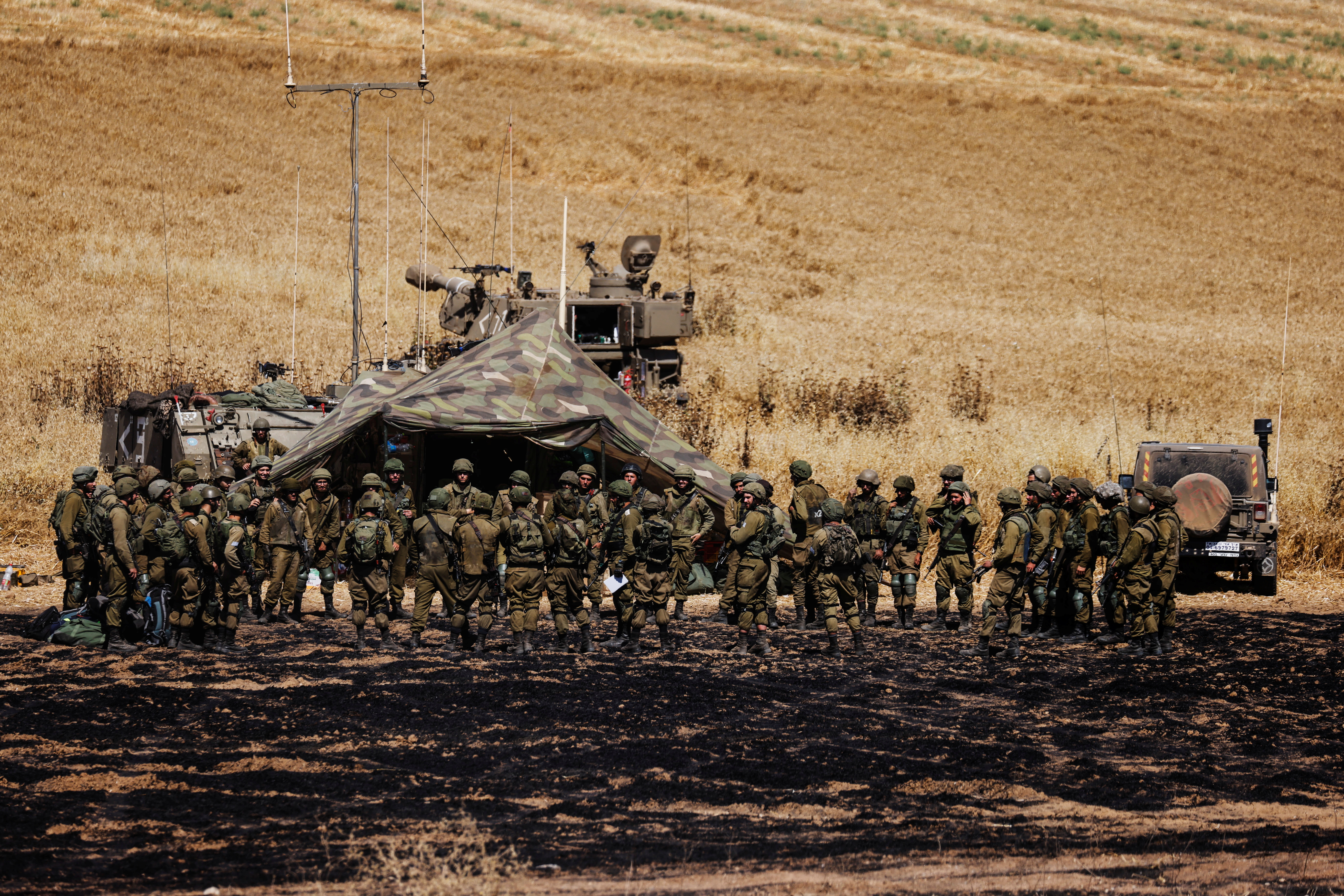 Israeli soldiers of an artillery unit gather near the border between Israel and the Gaza Strip, on its Israeli side