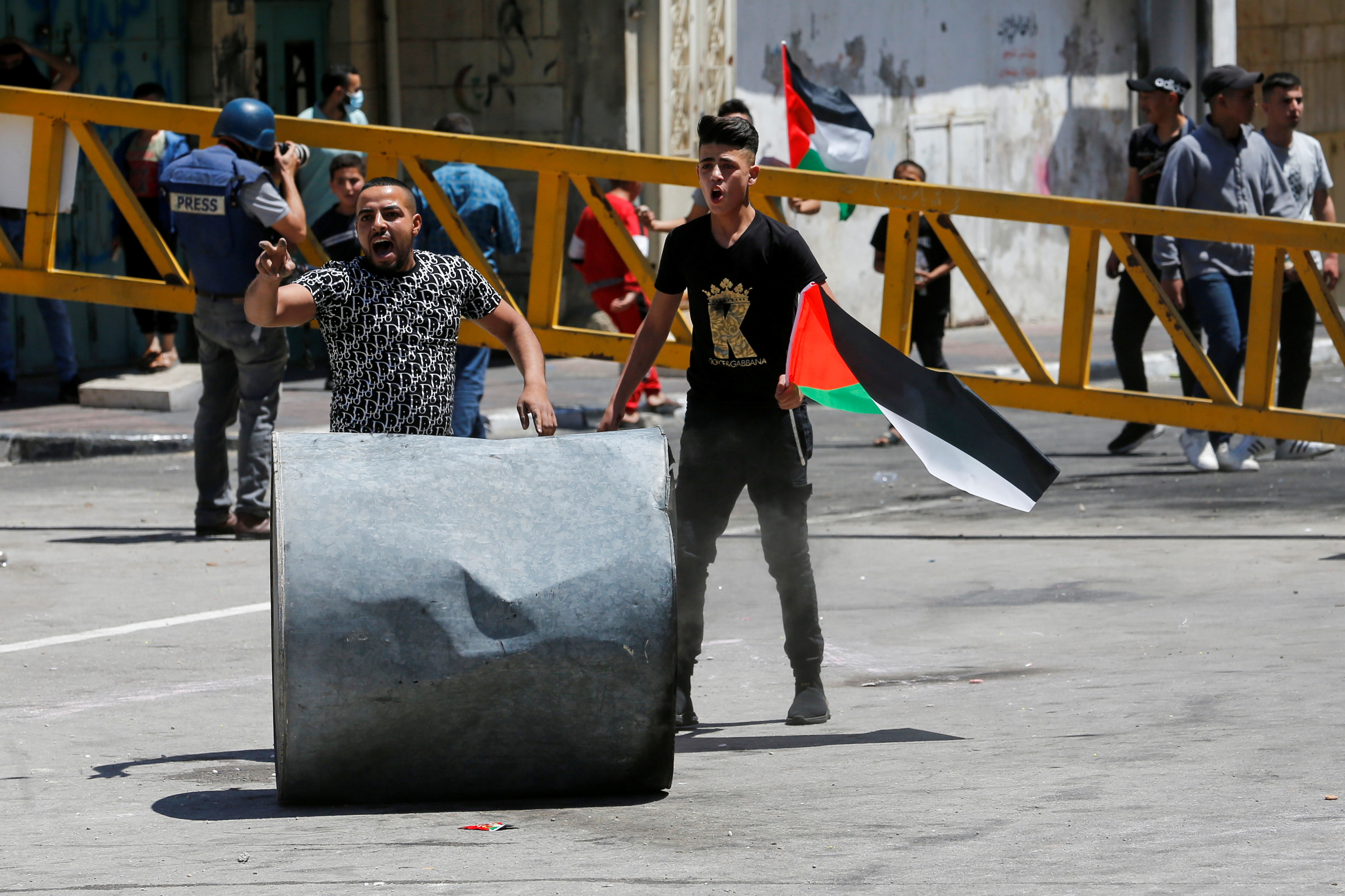 Palestinian demonstrators react during a protest over tension in Jerusalem and the Israel-Gaza escalation, in Hebron in the Israeli-occupied West Bank