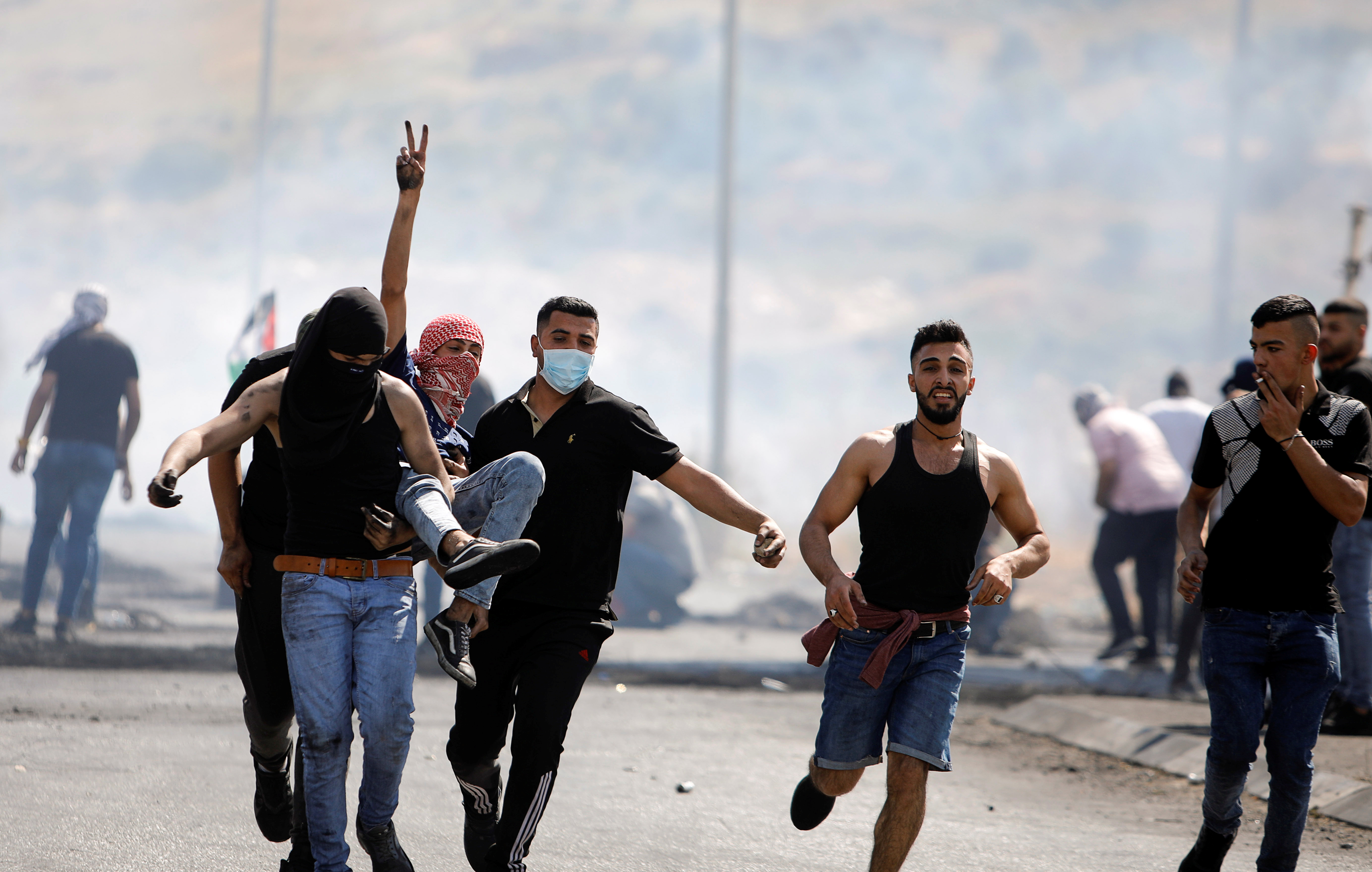 An injured Palestinian demonstrator is evacuated during protests with Israeli forces near Hawara checkpoint near Nablus in the Israeli-occupied West Bank