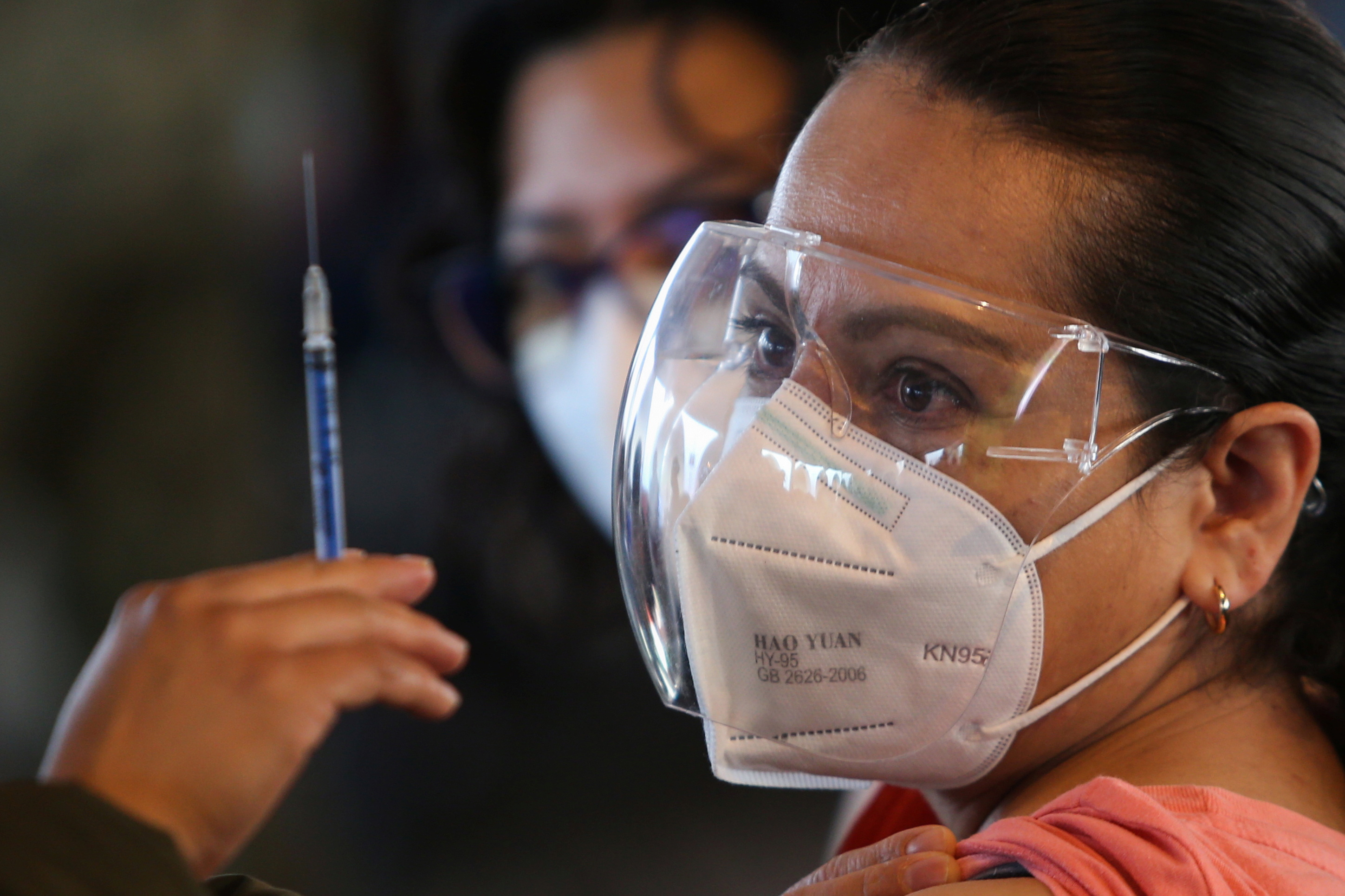 A teacher receiving China’s CanSino COVID-19 vaccine during a mass vaccination drive for teachers and school staff in Mexico City, Mexico