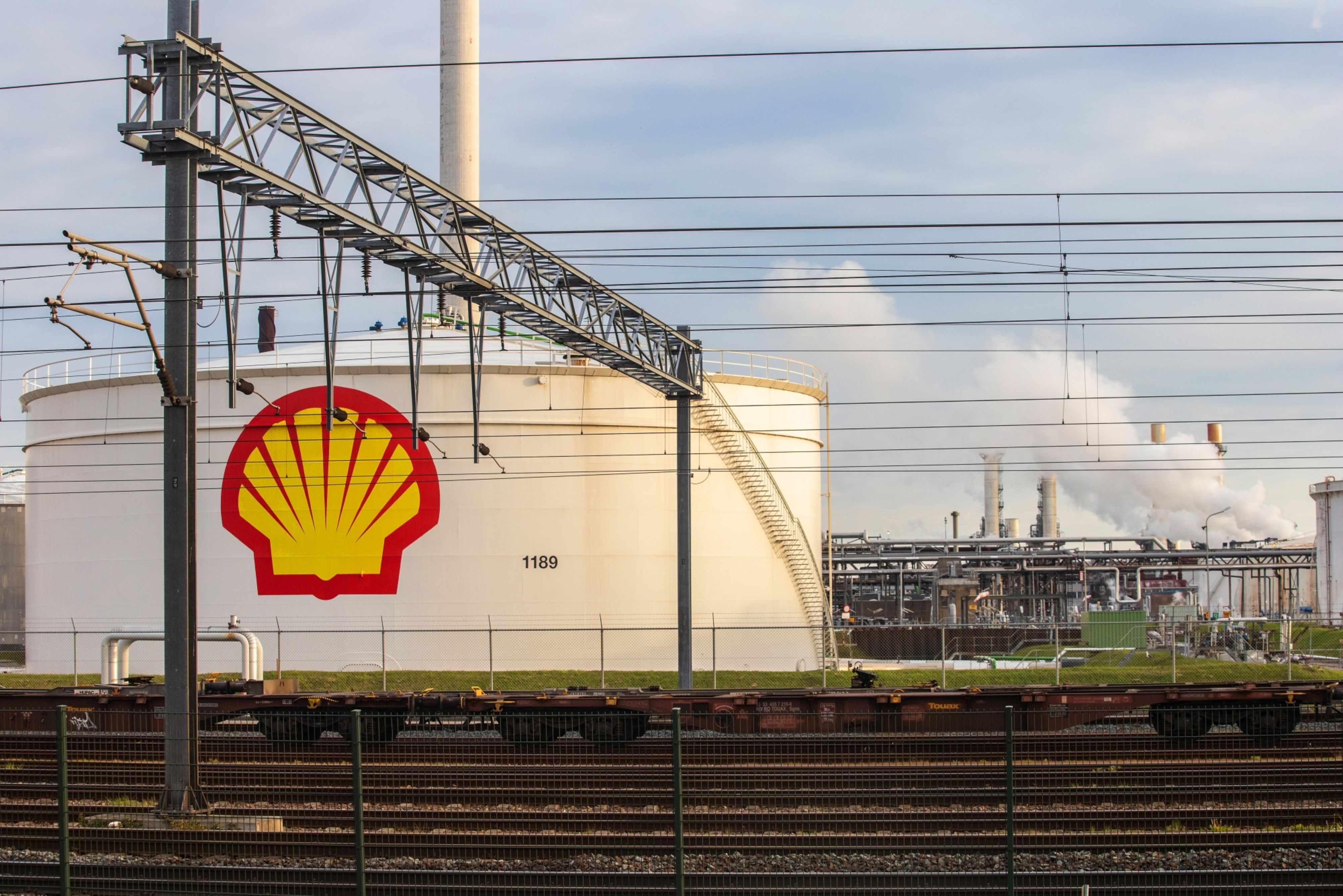 Railway wagon bogies beside a Royal Dutch Shell logo in the Netherlands File: Peter Boer/Bloomberg]