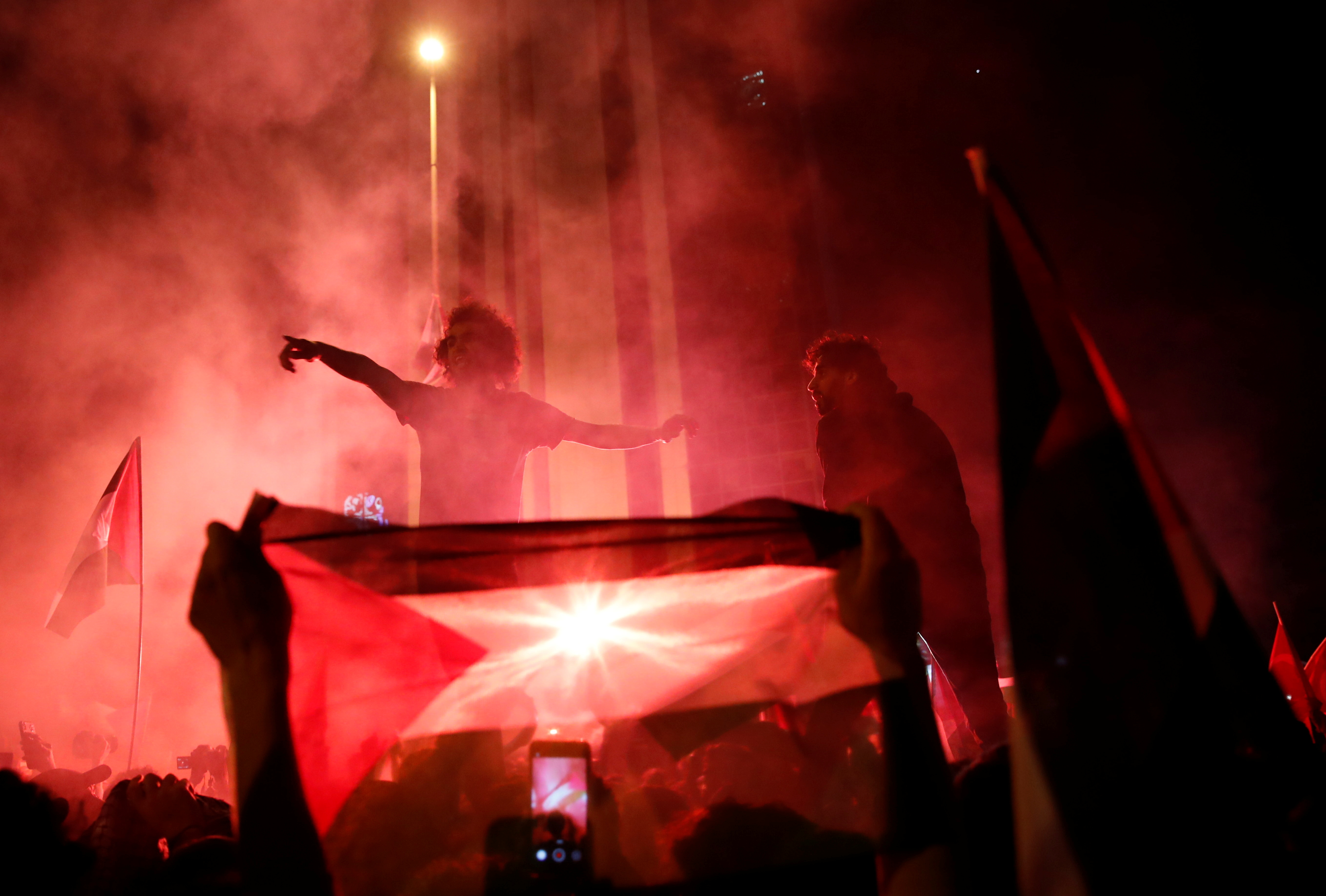 Demonstrators light flares during a protest near the Israeli consulate in Istanbul