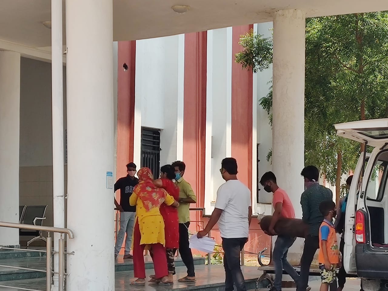 A female patient is supported by her children while companions carry an oxygen cylinder behind her as she enters the COVID-dedicated hospital in Lal Ganj in the Rae Bareli district