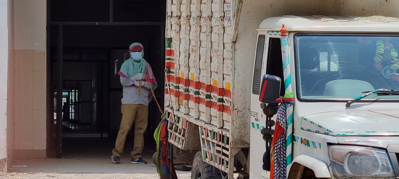 A worker unloads oxygen cylinders at the L2 hospital in Lal Ganj