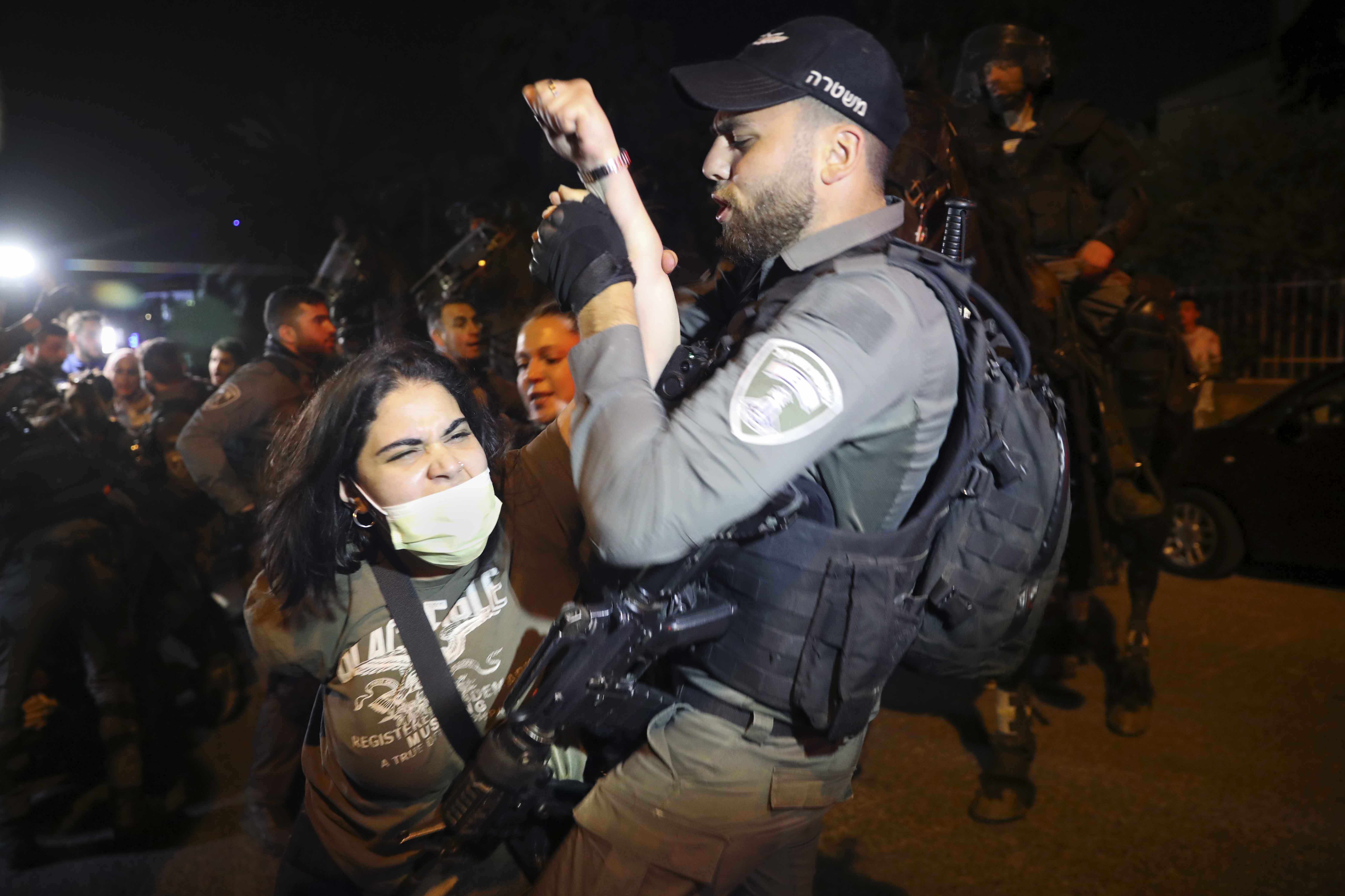 A Palestinian woman is manhandled by an Israeli policeman in the Sheikh Jarrah neighbourhood of East Jerusalem [Mahmoud Illean/AP]