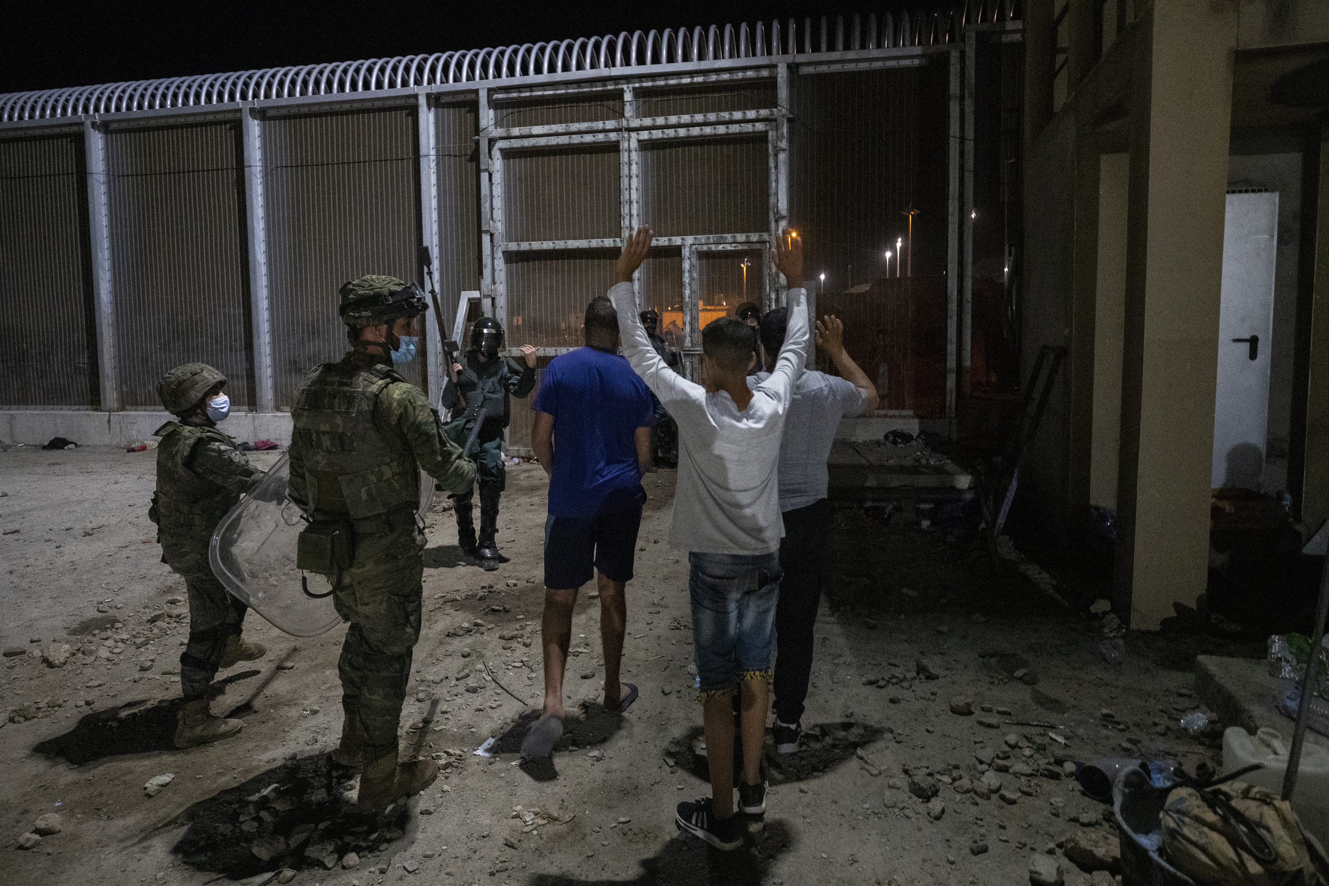 Spanish security forces expel migrants from the Spanish enclave of Ceuta, at the border of Morocco and Spain, late Tuesday, May 18, 2021. Spain deployed its military to the Moroccan border Tuesday as thousands of migrants jumped fences or swam onto European soil for the second day in a row after Rabat loosened border controls amid a deepening diplomatic spat. (AP Photo/Bernat Armangue)