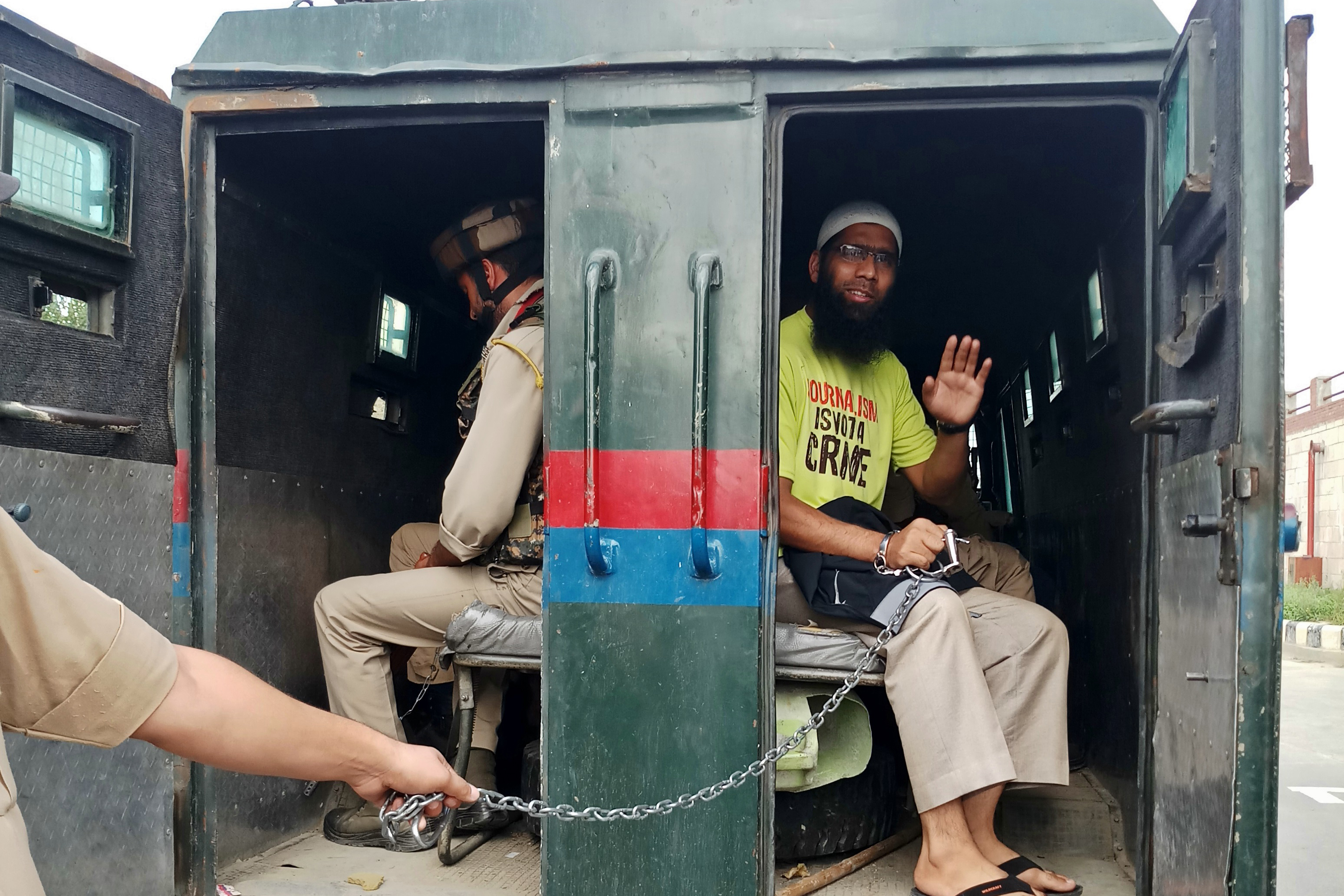 Sultan seen waving to his relatives from the police vehicle outside a Srinagar court
