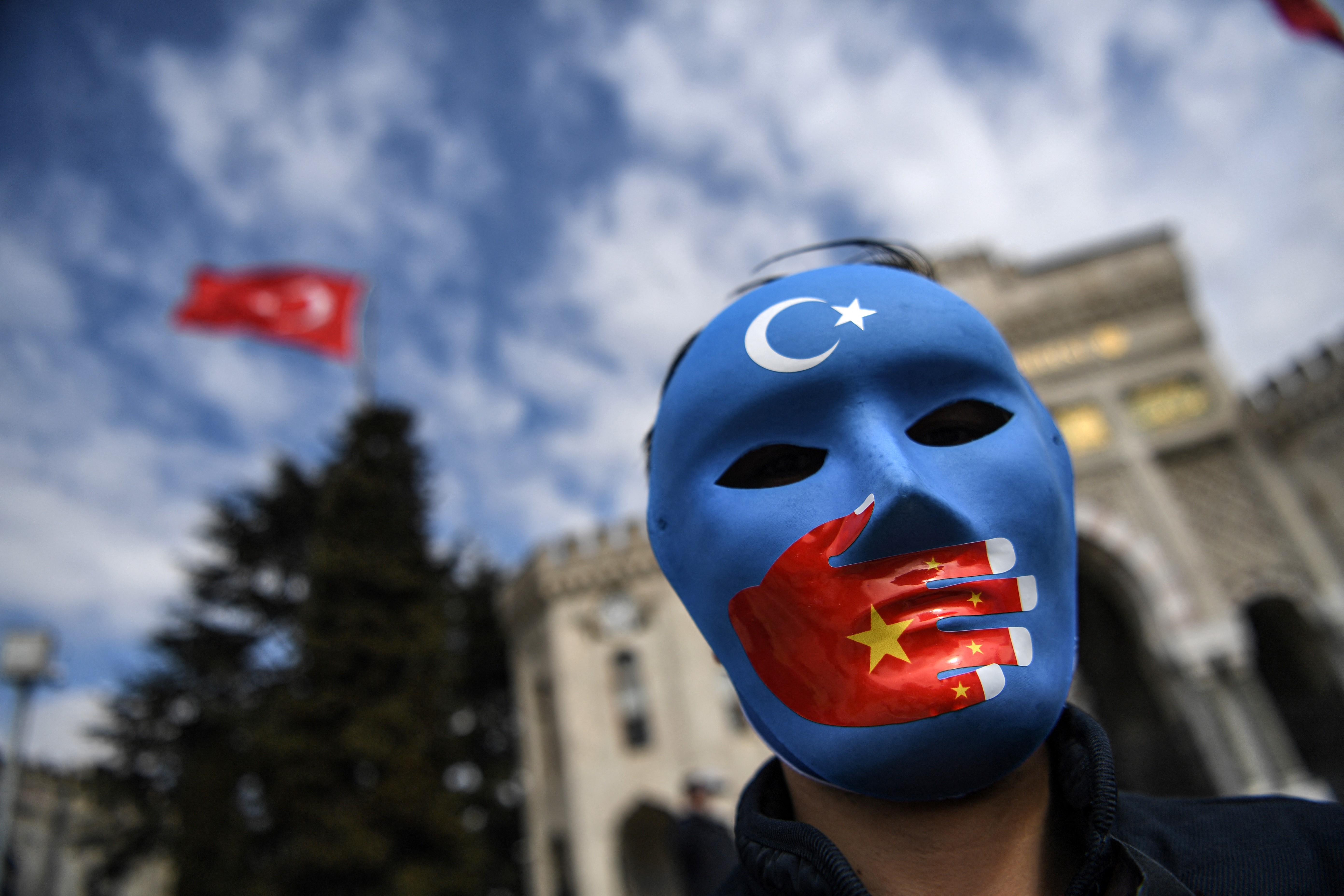 A demonstrator wearing a mask painted with the colours of the flag of East Turkestan takes part in a protest by supporters of China’s Uighur minority in April in Istanbul