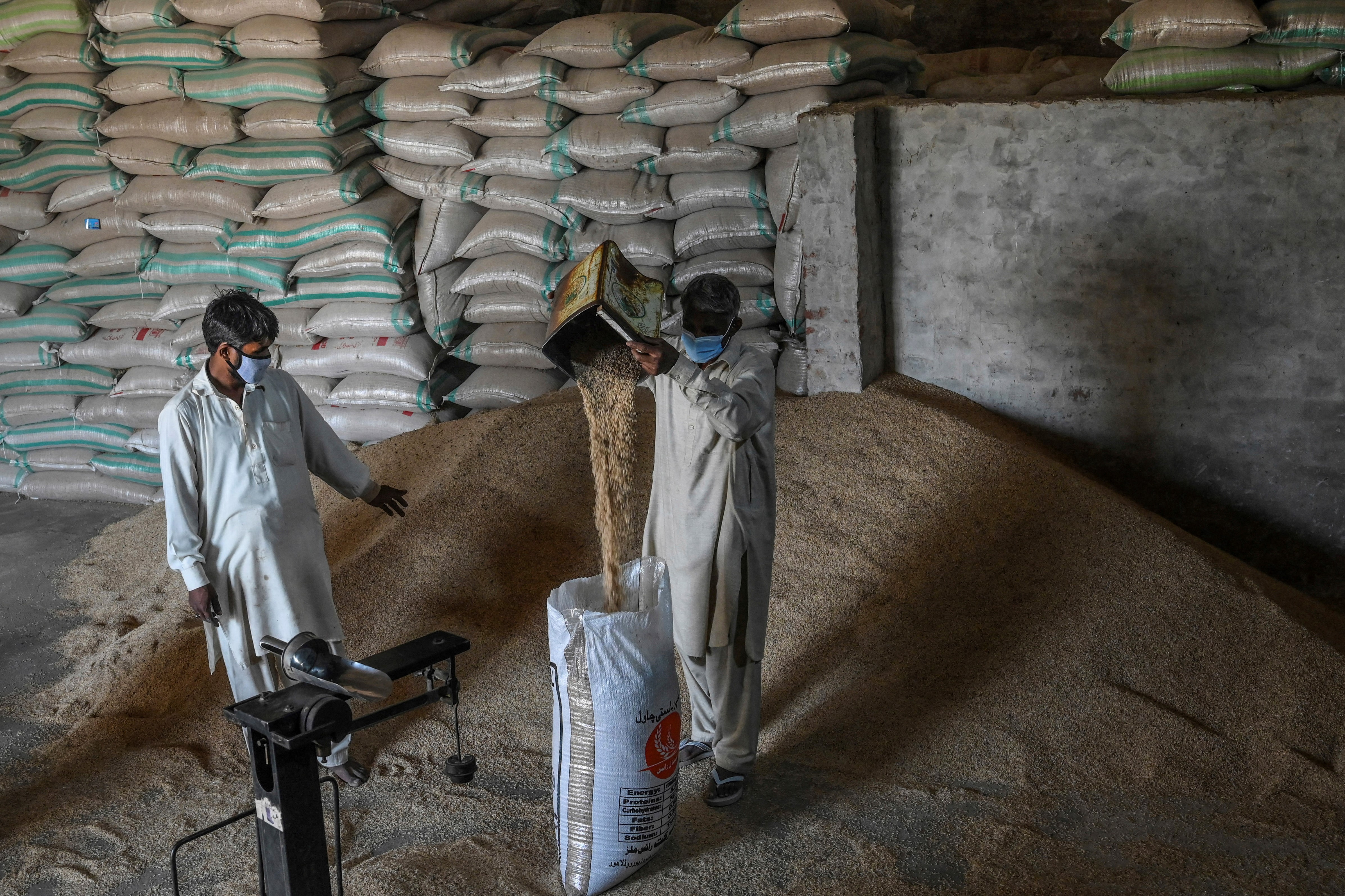 A Pakistani worker fills a sack with rice at the Al-Barkat Rice Mills on the outskirts of Lahore
