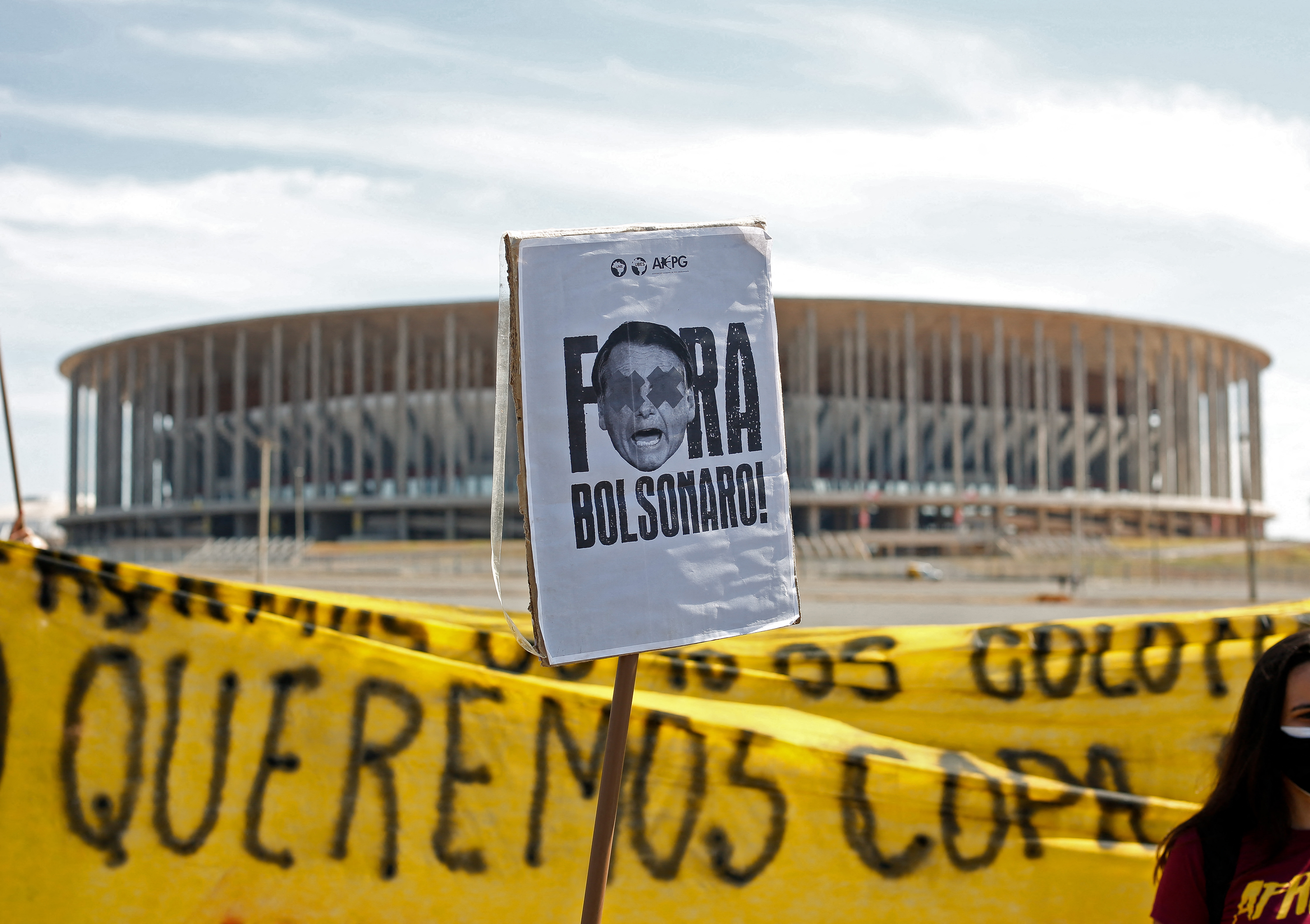 Protesters hold a sign reading ‘Bolsonaro out’ during a protest against the Copa America outside the Mane Garrincha stadium, where the tournament’s opening match between Brazil and Venezuela will take place, in Brasilia, on June 13
