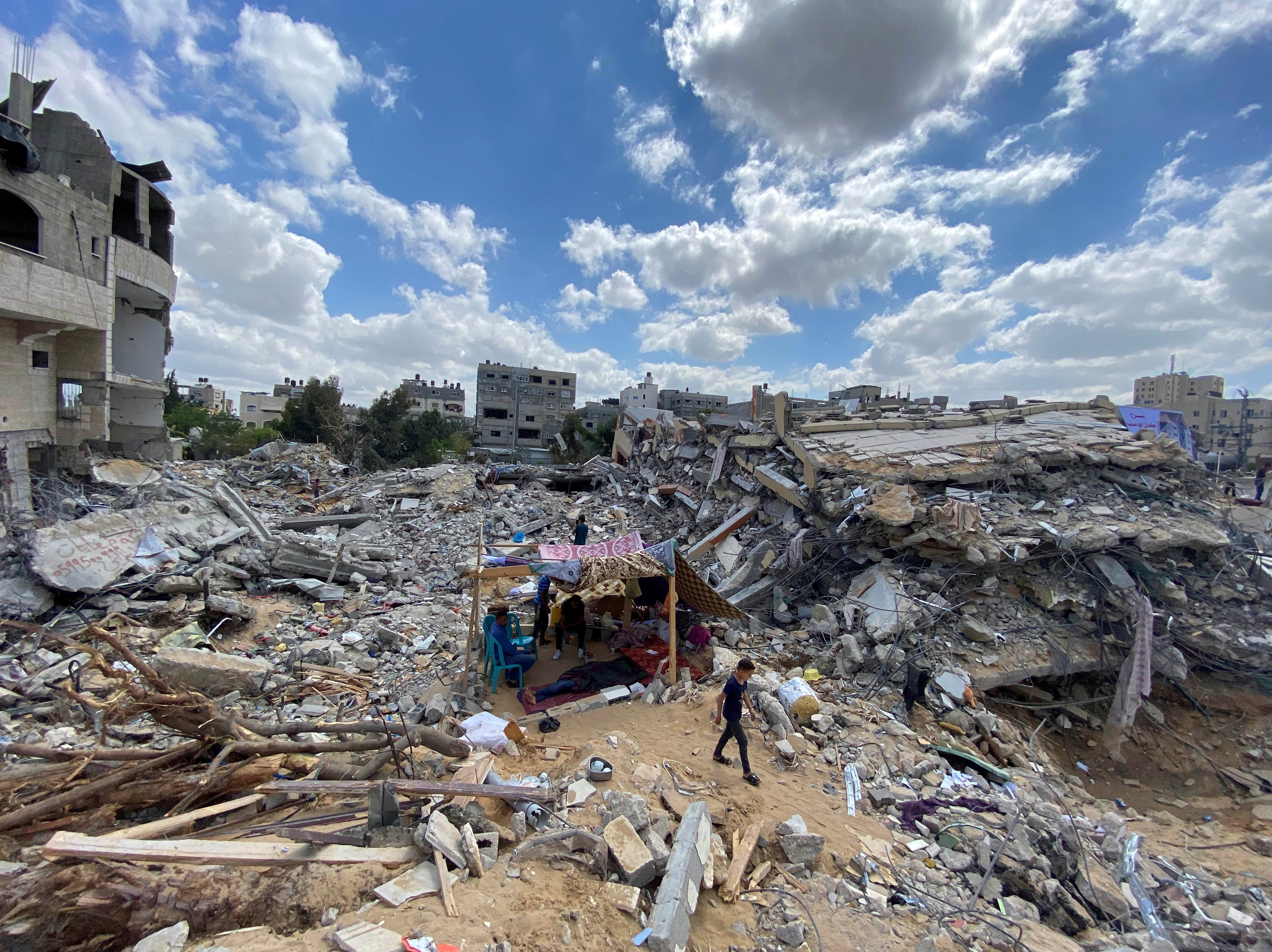 A Palestinian family in makeshift tent amid the rubble of houses destroyed by Israeli air attacks during the Israeli-Palestinian fighting in Gaza
