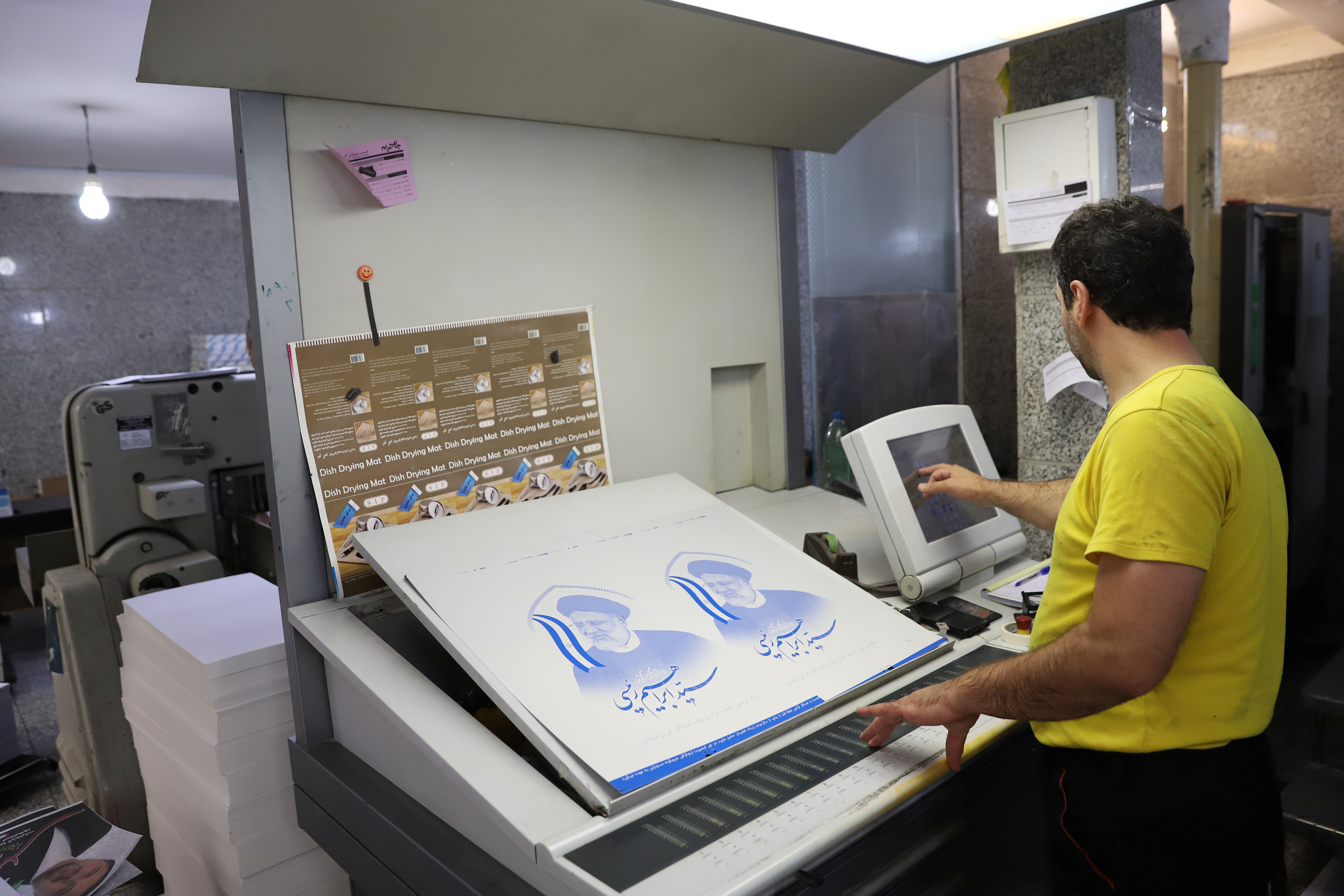 A printshop worker prepares presidential election posters in Tehran, Iran