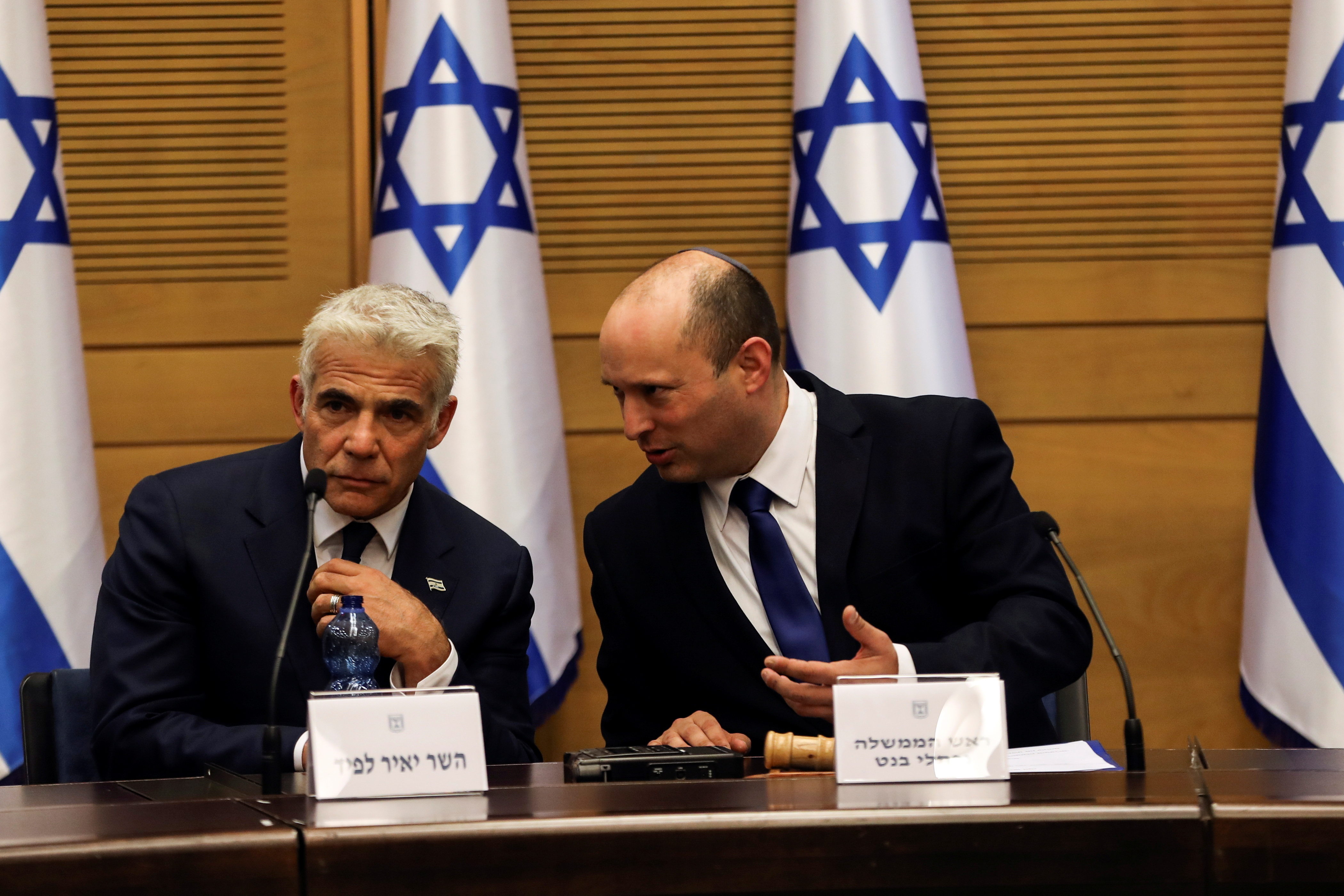 Israeli Prime minister Naftali Bennett and Foreign Minister Yair Lapid attend its first cabinet meeting in the Knesset, Israel’s parliament, in Jerusalem, June 13, 2021.