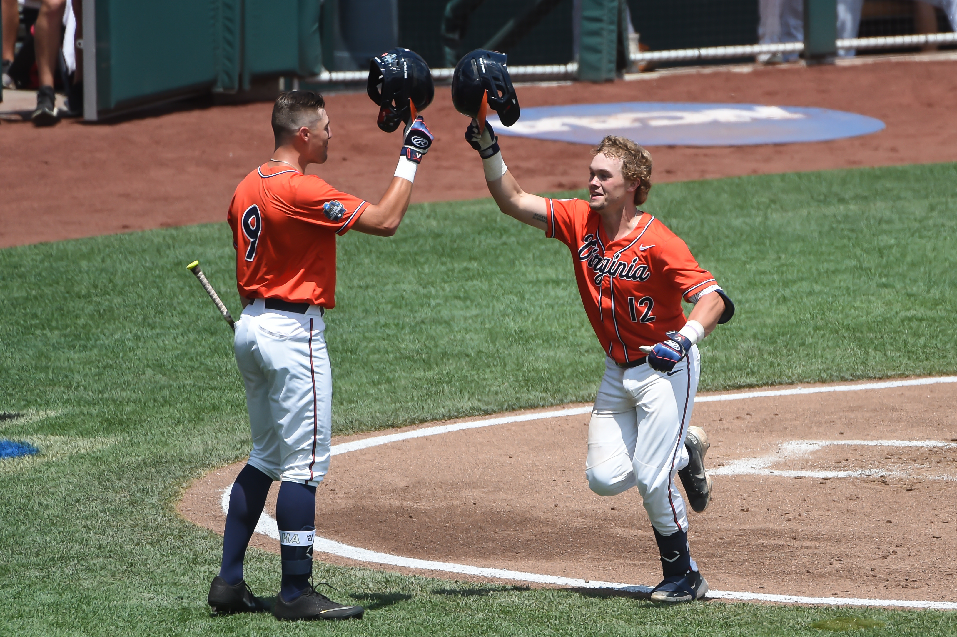 Virginia Cavaliers catcher Logan Michaels (right) celebrating with outfielder Chris Newell after hitting a home run in the third inning against the Tennessee Volunteers