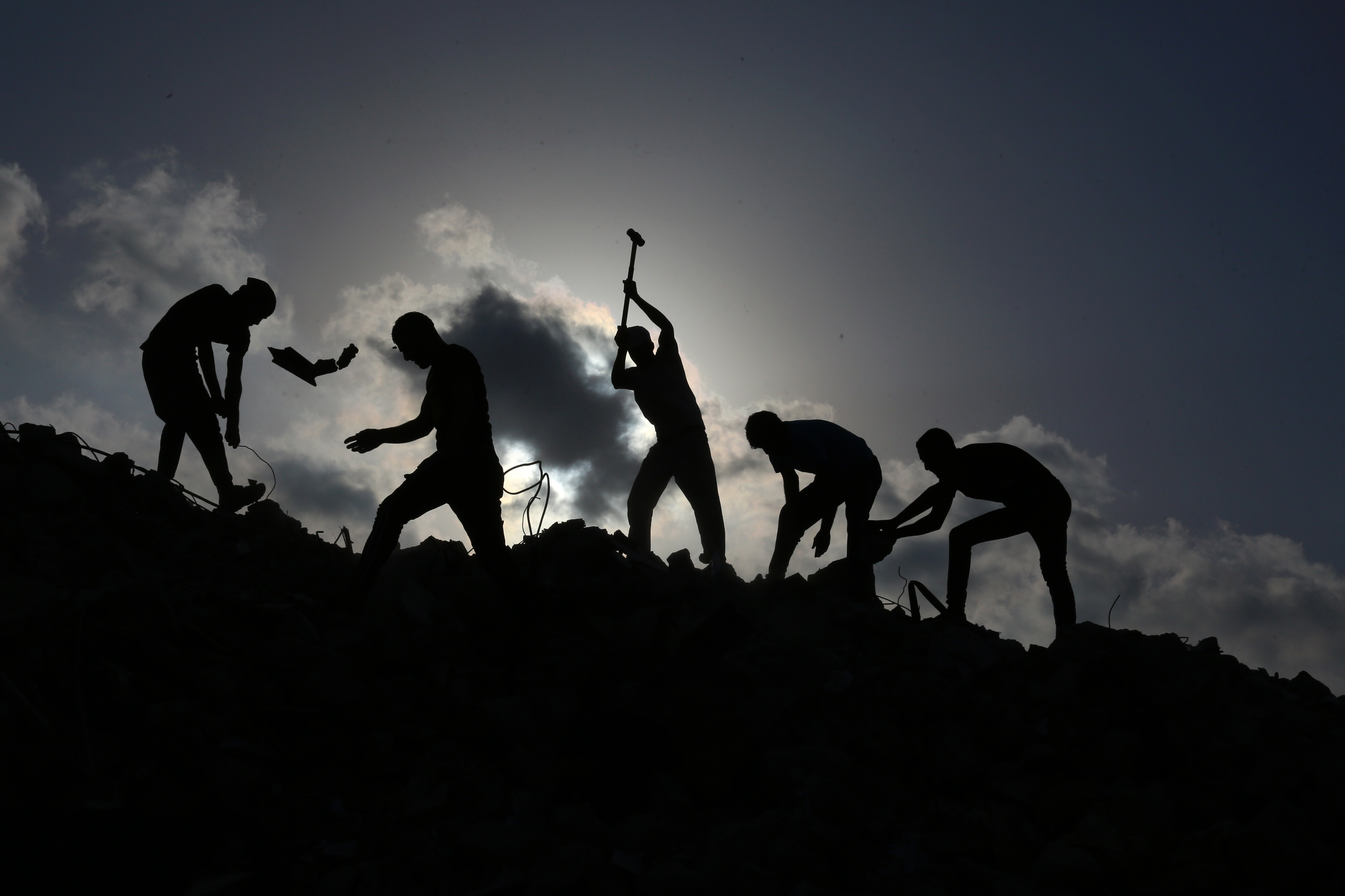 Workers toil to extract metal and concrete from the debris