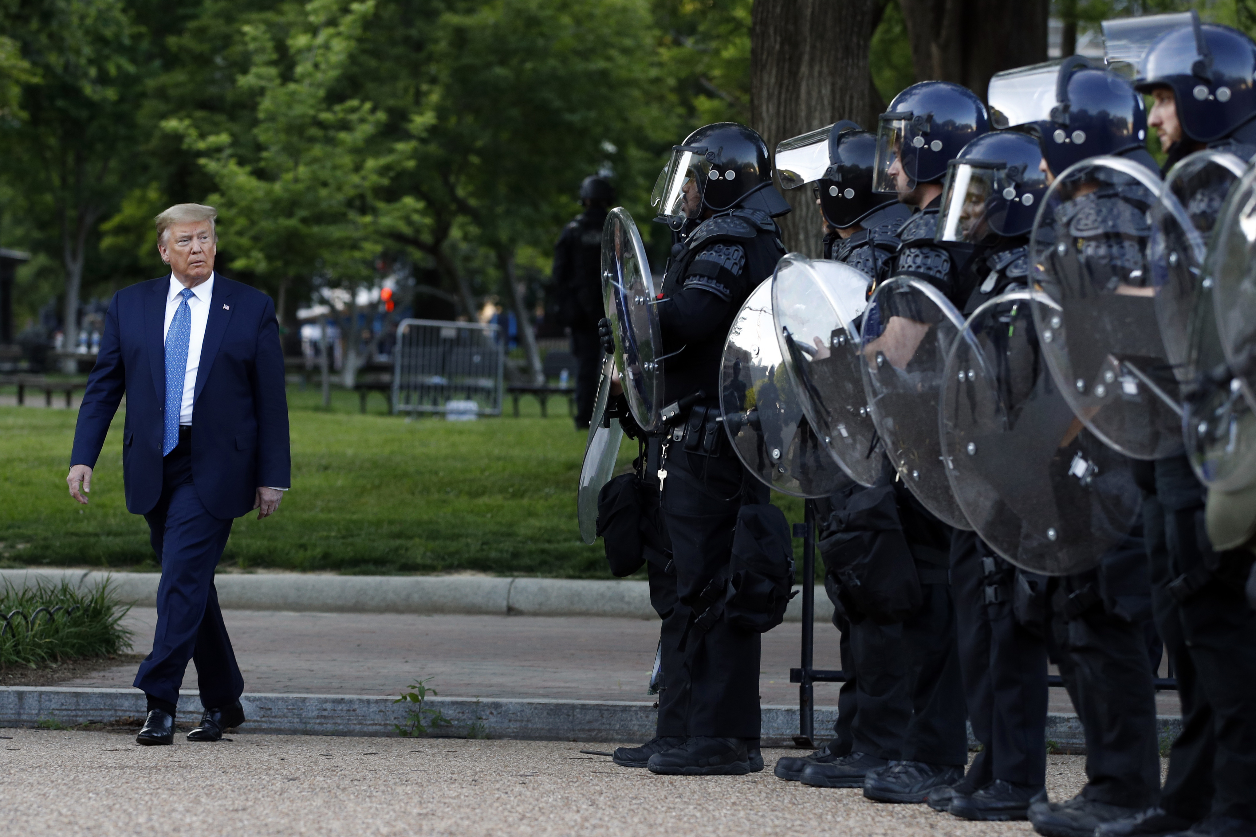 Then-President Donald Trump walks past police in Lafayette Park after he visited St John’s Church in Washington, DC, after racial justice protesters had been forcibly cleared [File: Patrick Semansky)