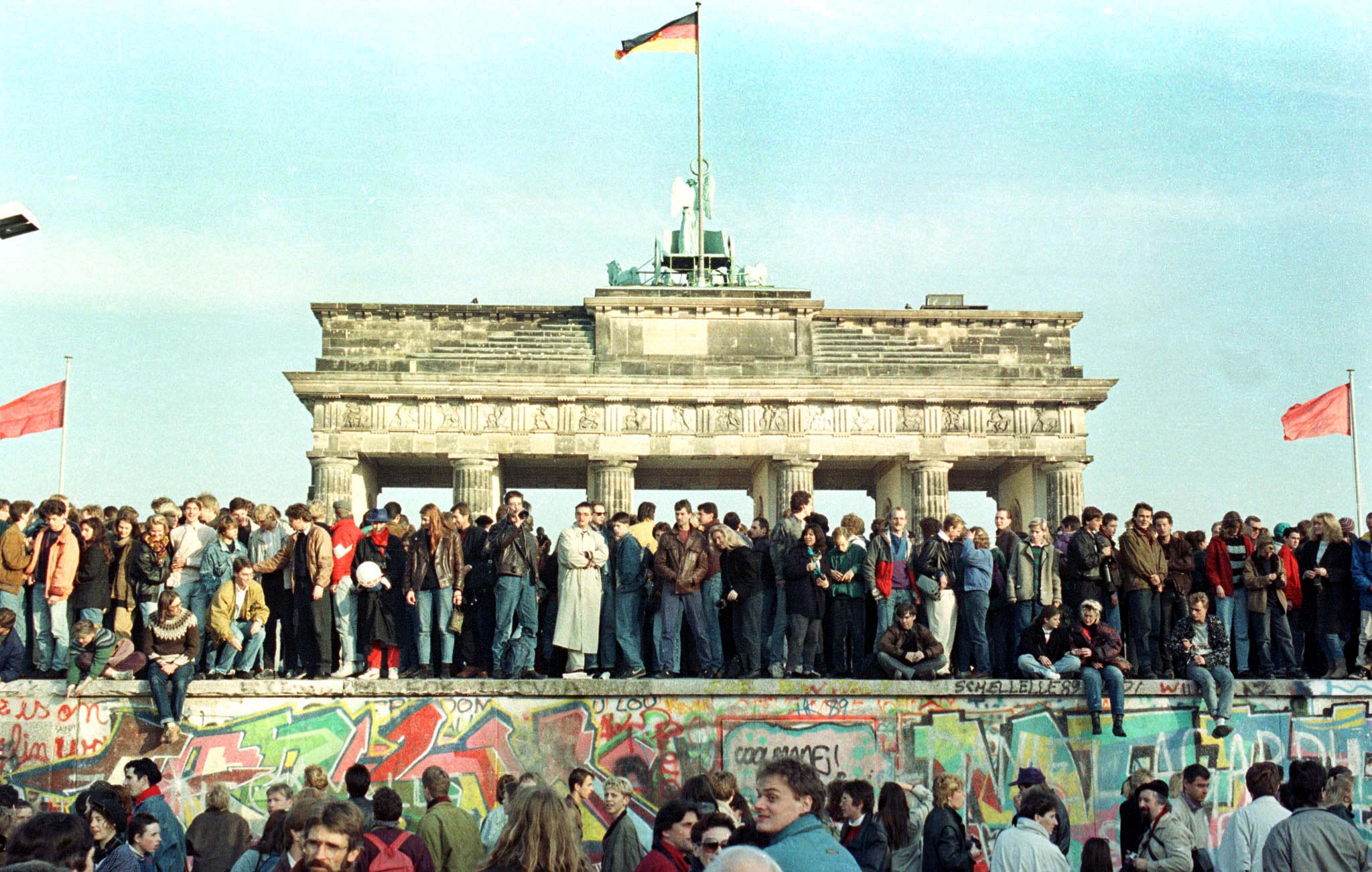 Citizens of West Berlin hold a vigil on the Berlin Wall on November 10, 1989