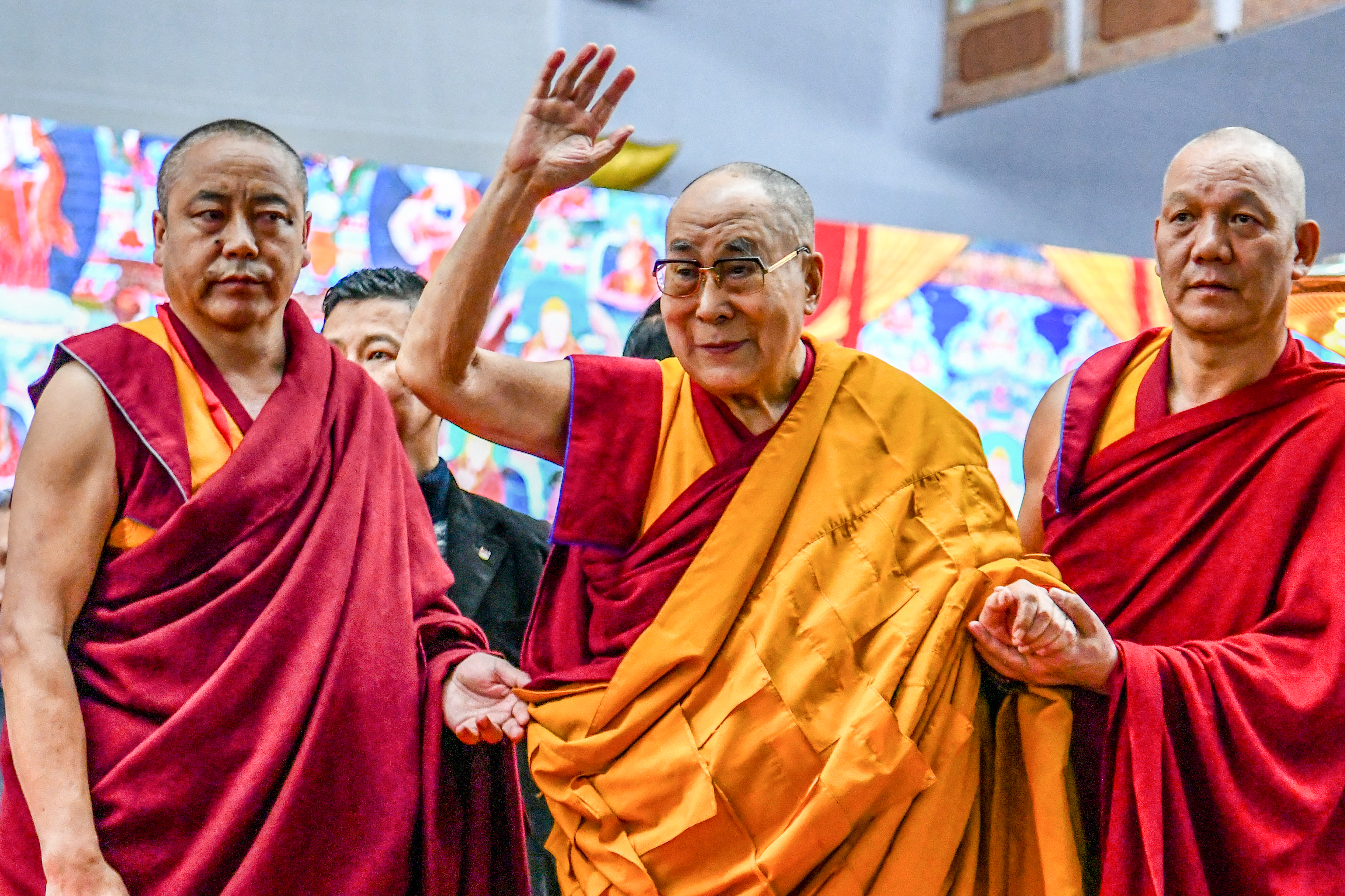 Tibetan spiritual leader the Dalai Lama, centre, waves to the crowd during an event in Bodhgaya, India [File: STR/AFP]