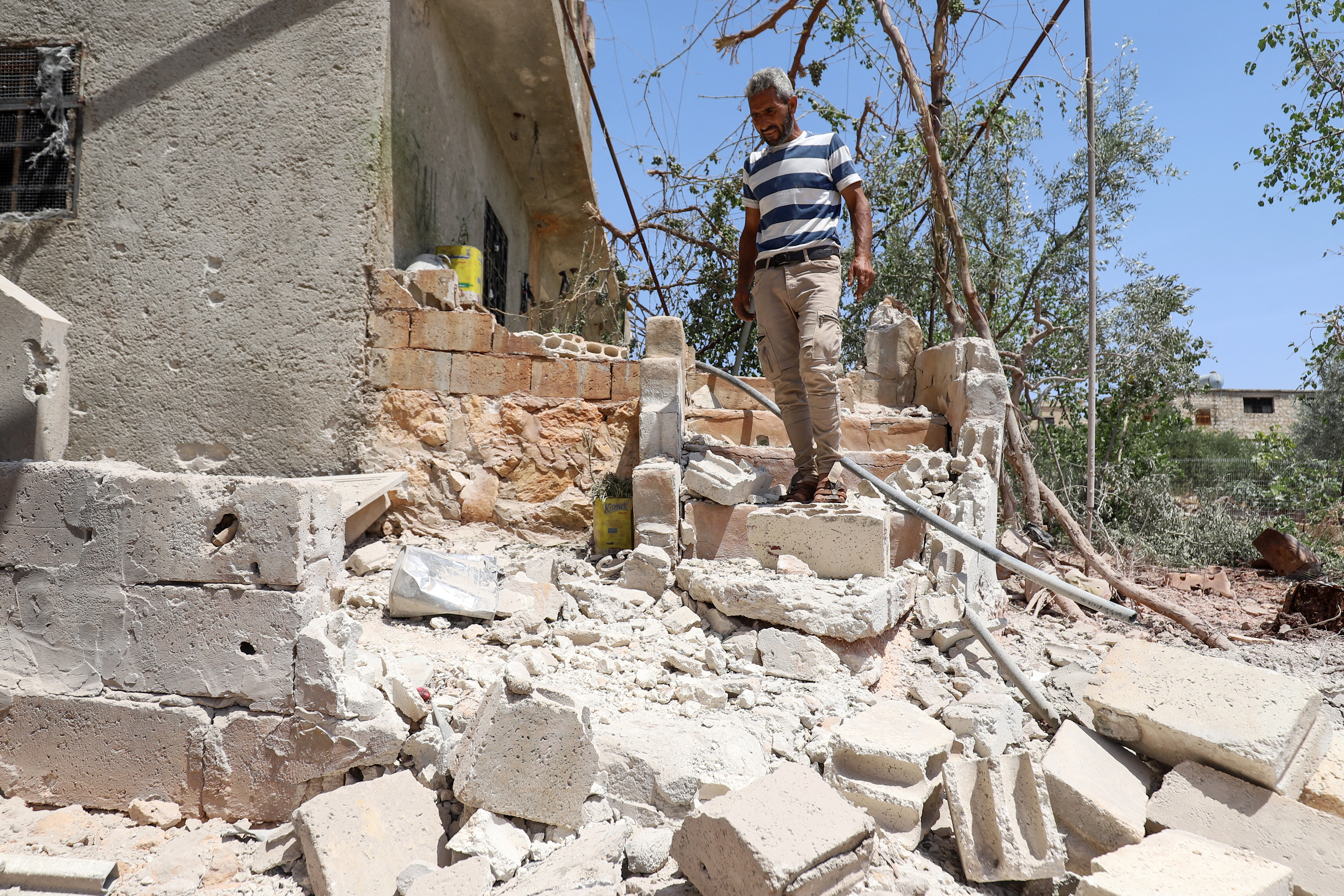 A Syrian man inspects a damaged house following a reported regime artillery shelling in northwestern Idlib province