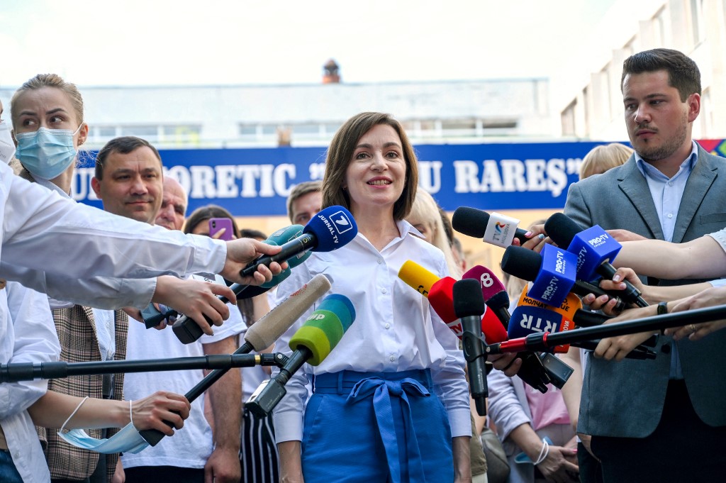 Sandu (C) speaks with journalists outside a polling station in Chisinau