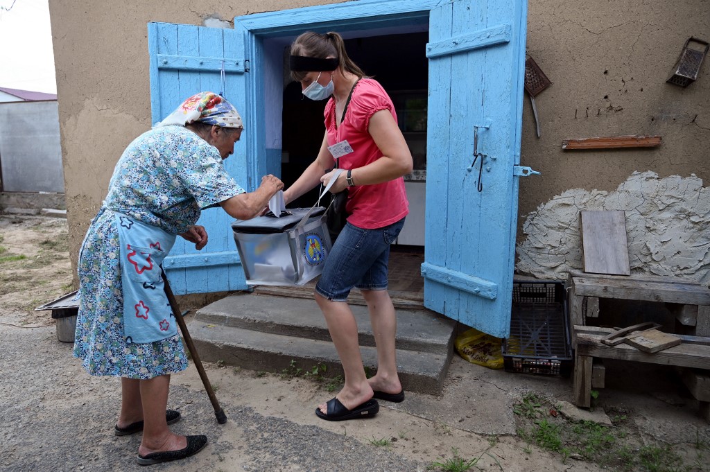 A woman casts her ballot in the village of Gura Bicului