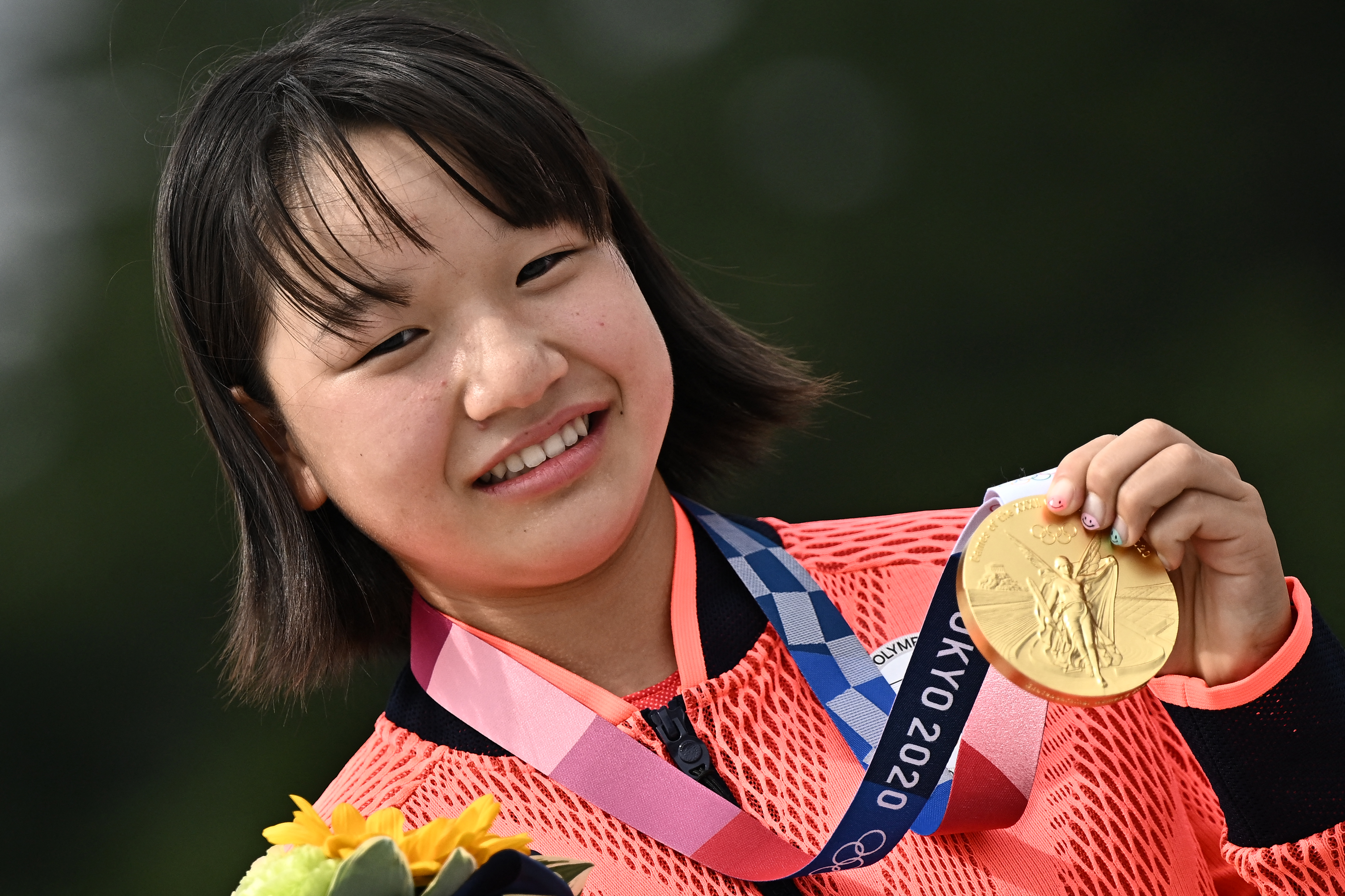 Japan’s Nishiya poses with her gold medal during the podium ceremony of the skateboarding women’s street final of Tokyo 2020