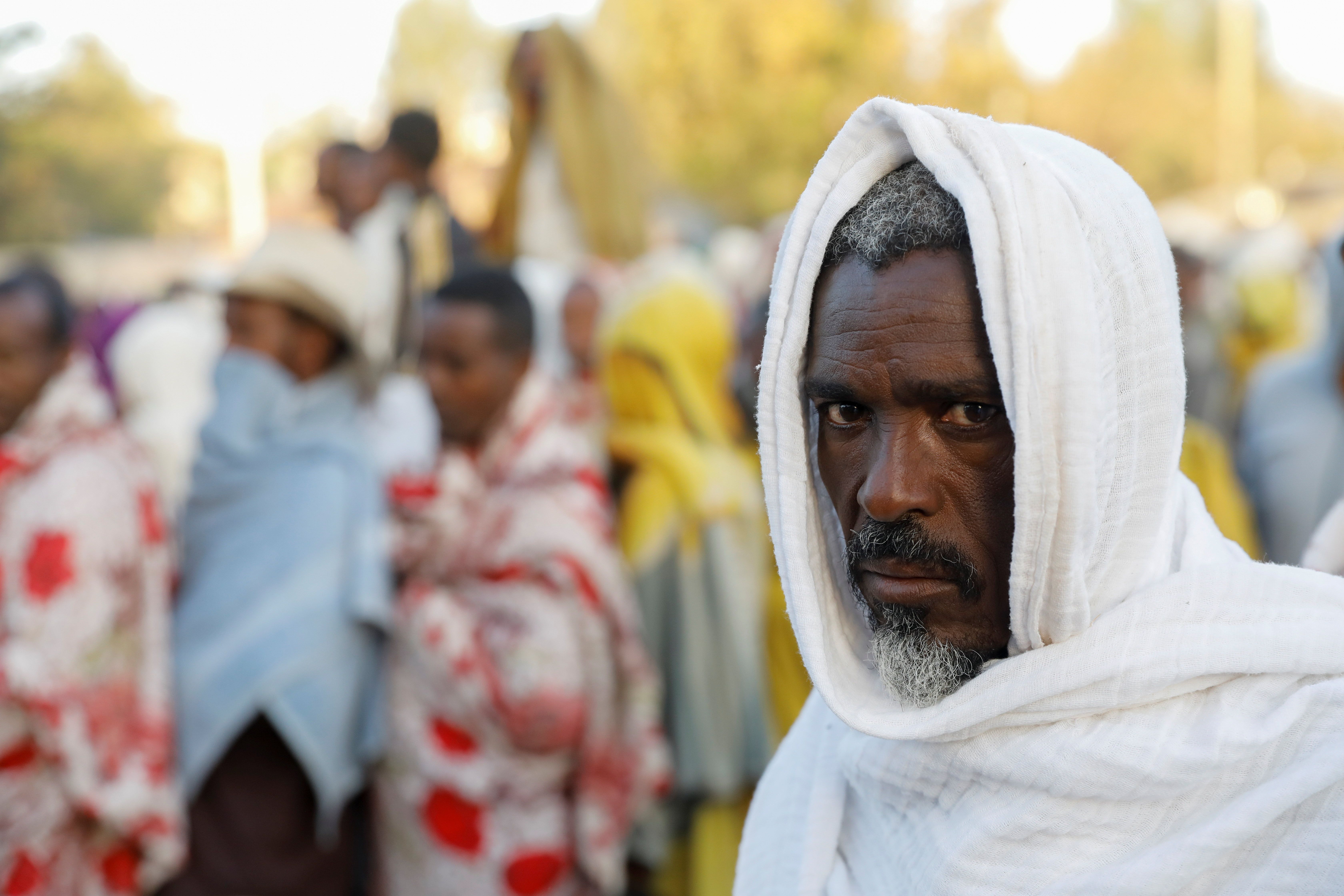 A man stands in line to receive food donations, at the Tsehaye primary school, which was turned into a temporary shelter for people displaced by conflict, in the town of Shire, Tigray region, Ethiopia, March 15, 2021.