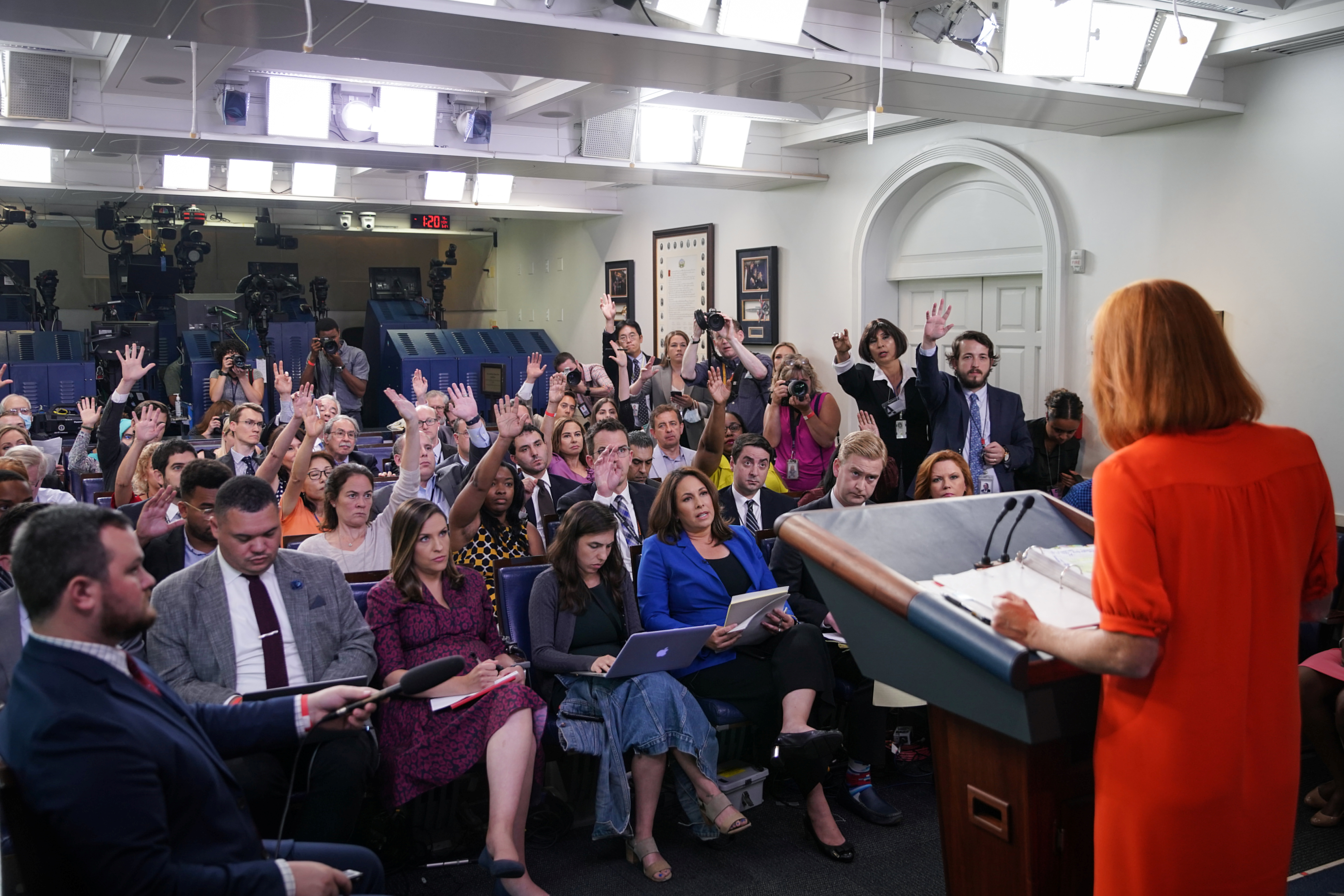 Members of the press raising their hands to ask questions during a press briefing with White House Press Secretary Jen Psaki at the White House in Washington