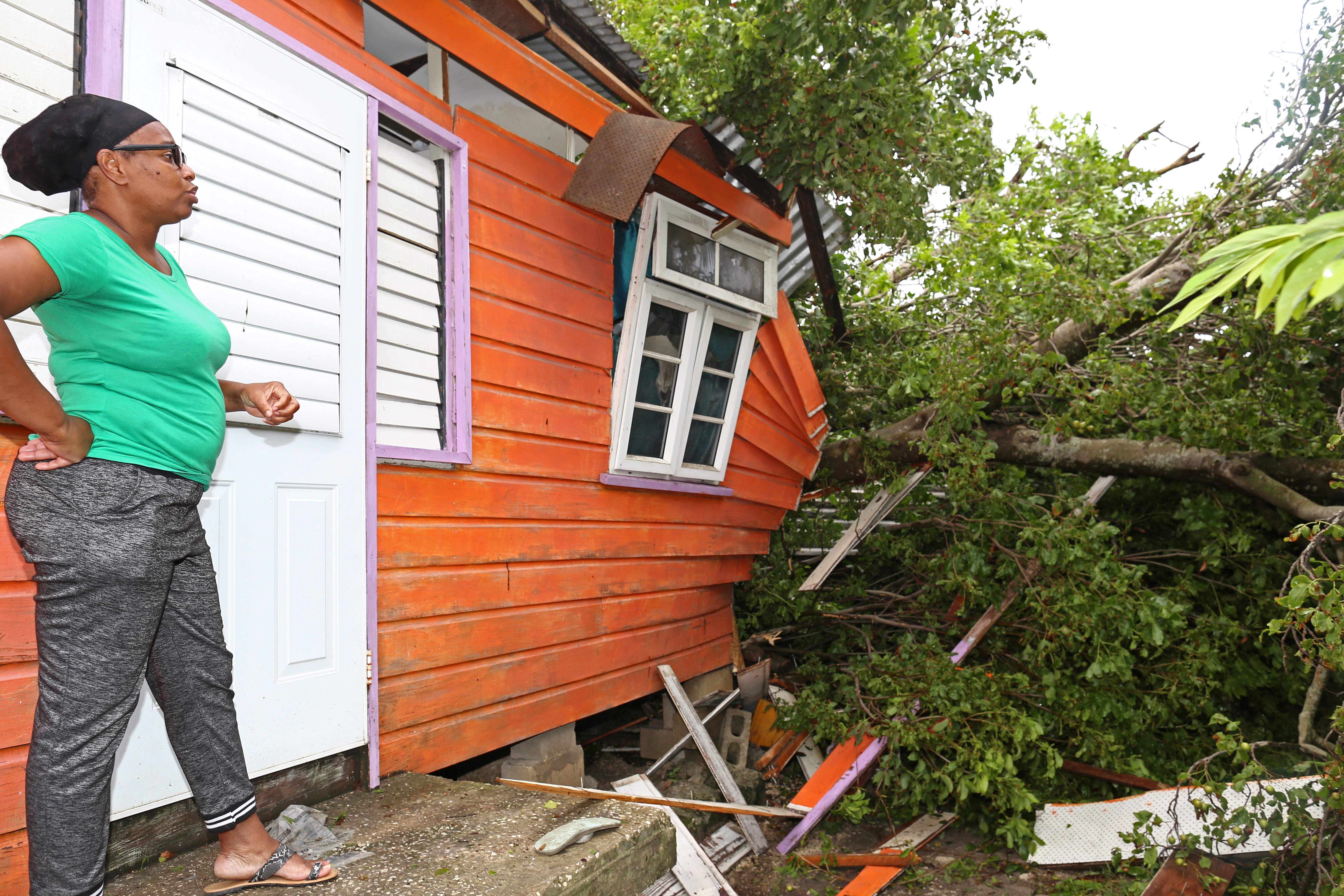 A woman views damage to a home after strong winds of Hurricane Elsa passed St Michael, Barbados, on July 2