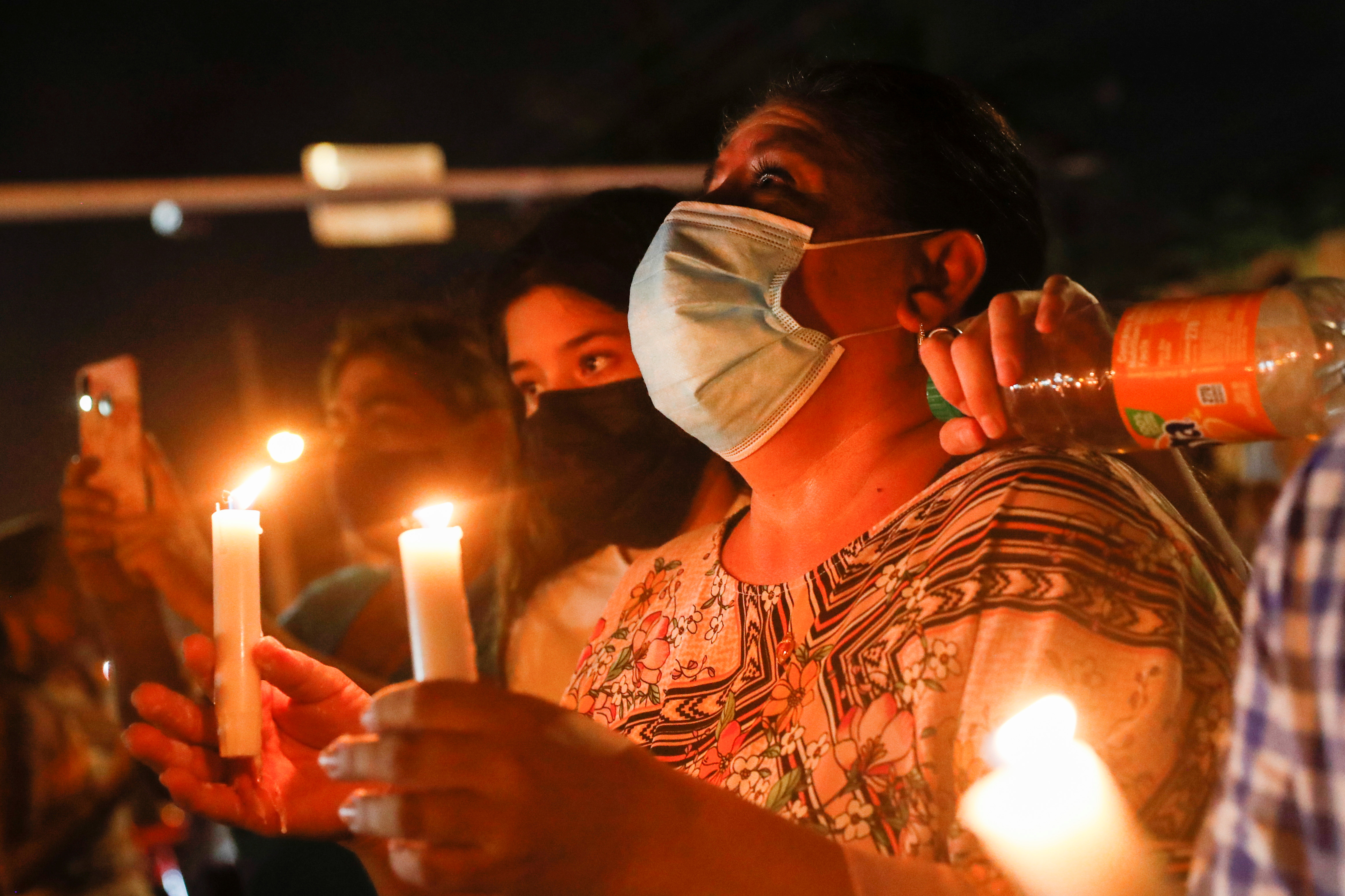 Stephanie Rioja attends a vigil as the partially collapsed Champlain Towers South residential building is demolished ahead of the possible arrival of Tropical Storm Elsa in Surfside, near Miami Beach, Florida, on July 4