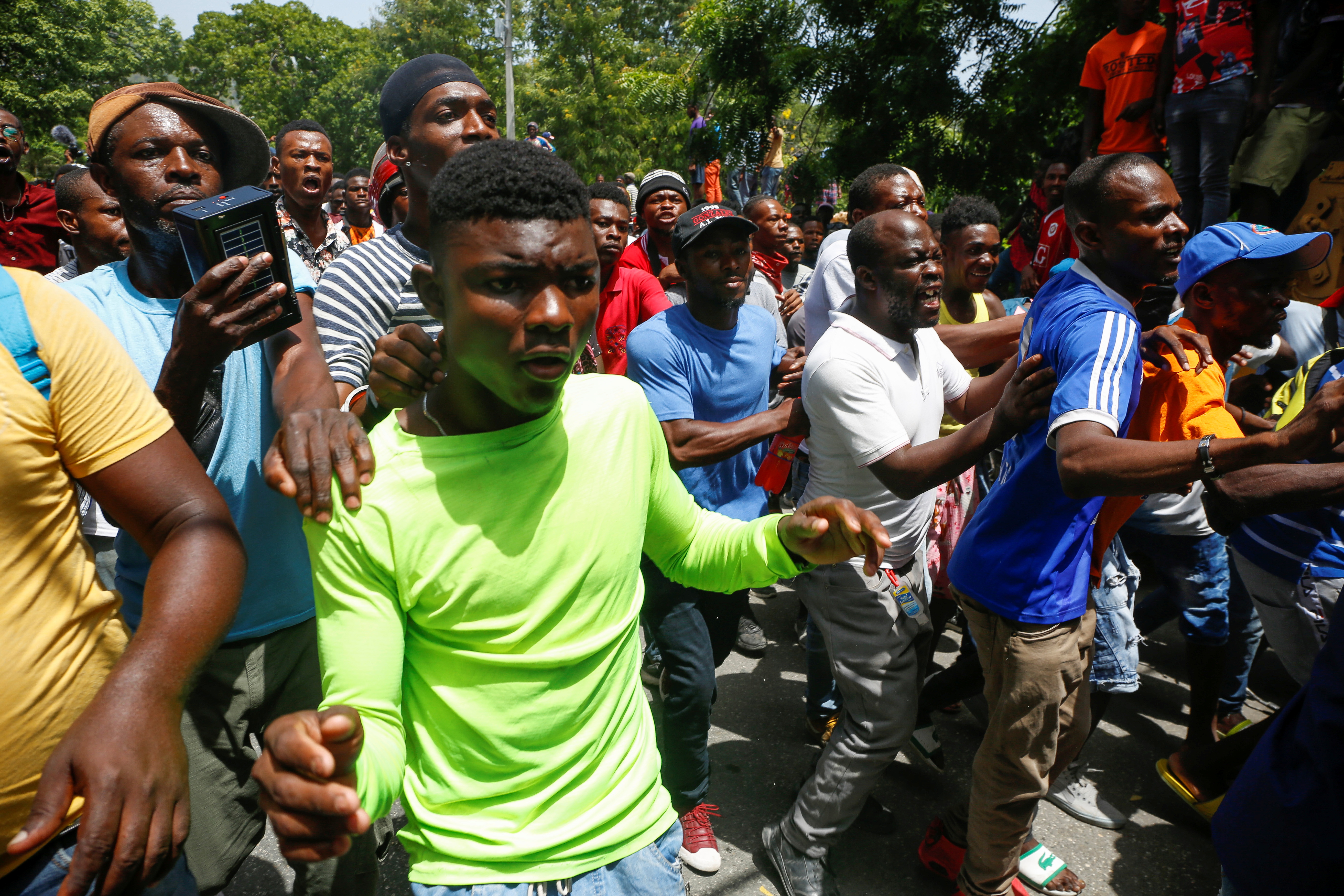 People react outside a police station where suspects in President Jovenel Moise’s killing were being held, in Port-au-Prince, on July 8