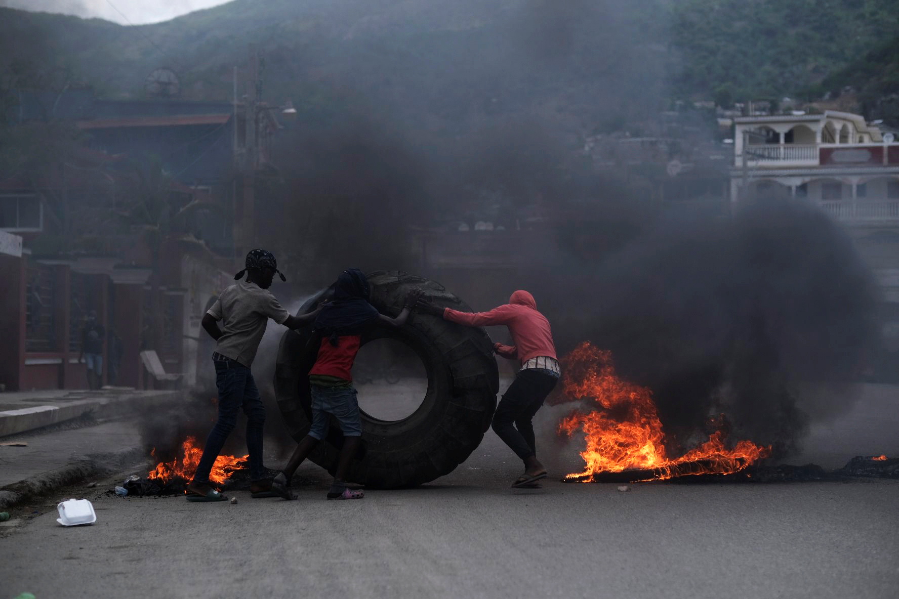 Demonstrators set tyres on fire during a protest against the assassination of Haitian President Jovenel Moise in Cap-Haitien, Haiti
