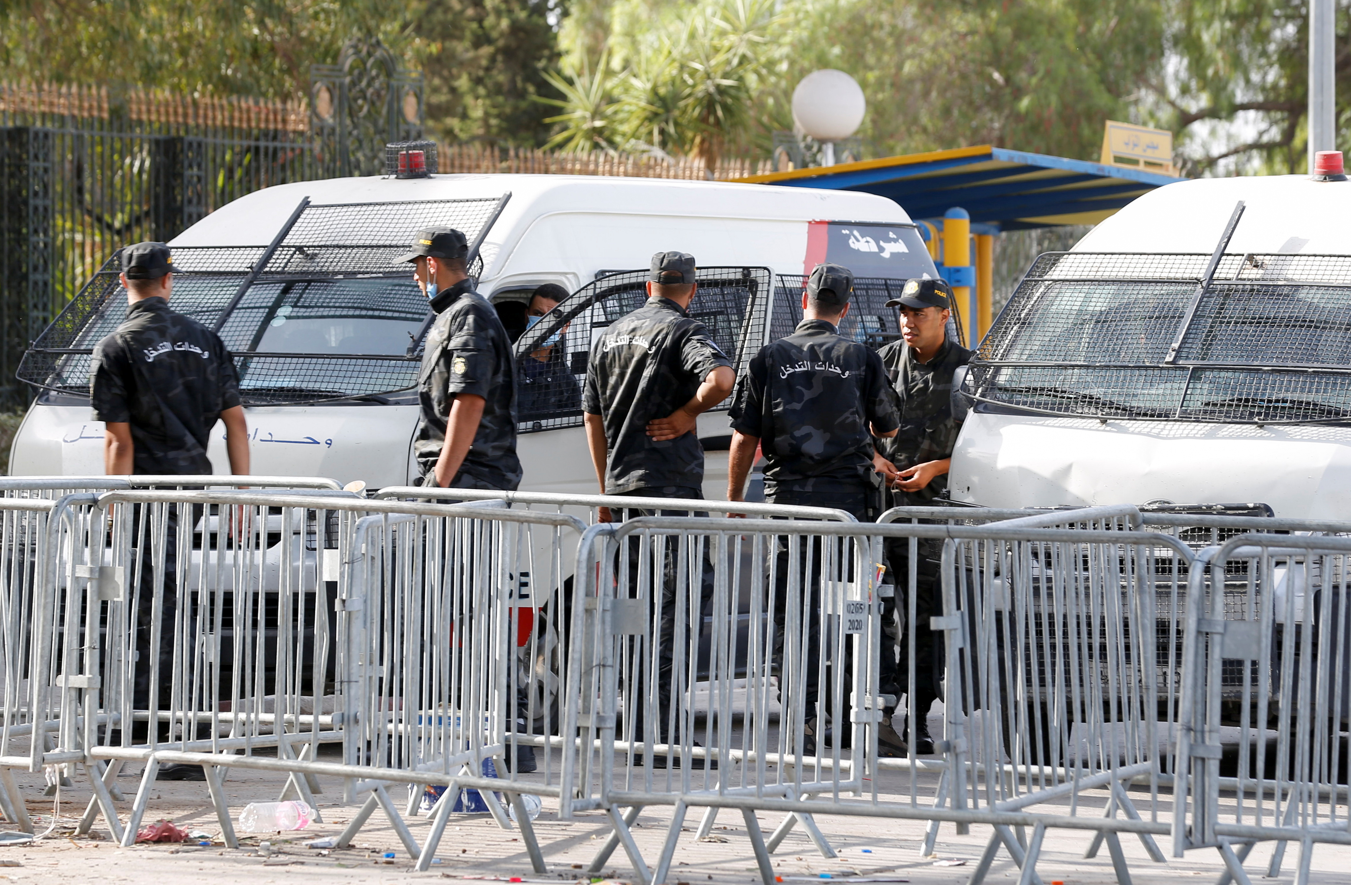 Police officers stand guard outside the parliament building in Tunis on Tuesday