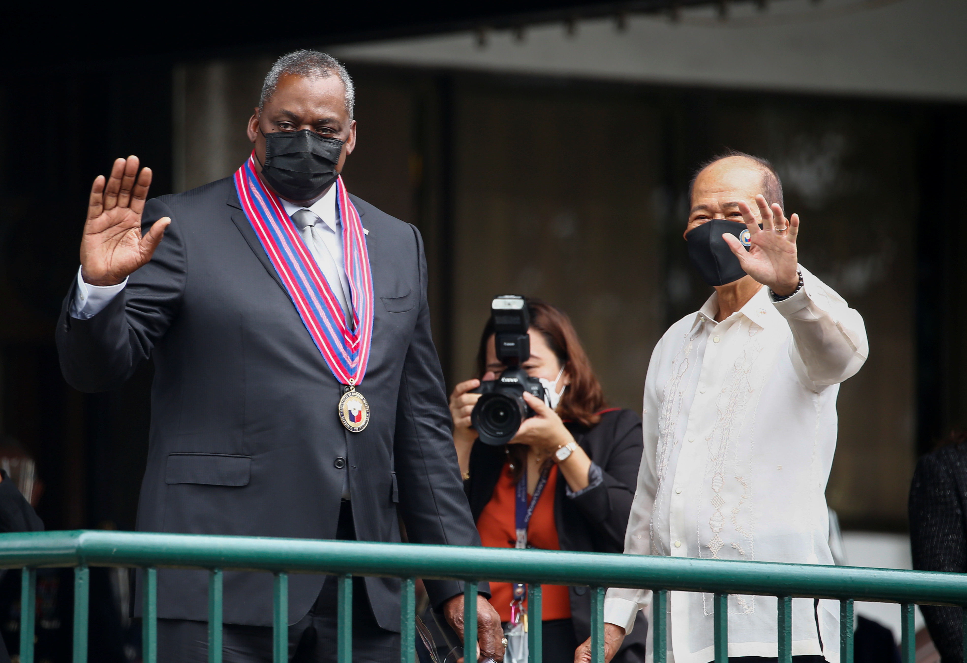 US Secretary of Defense Lloyd Austin and Philippines’s Defence Secretary Delfin Lorenzana wave before holding a bilateral meeting at Camp Aguinaldo military camp in Manila on Friday