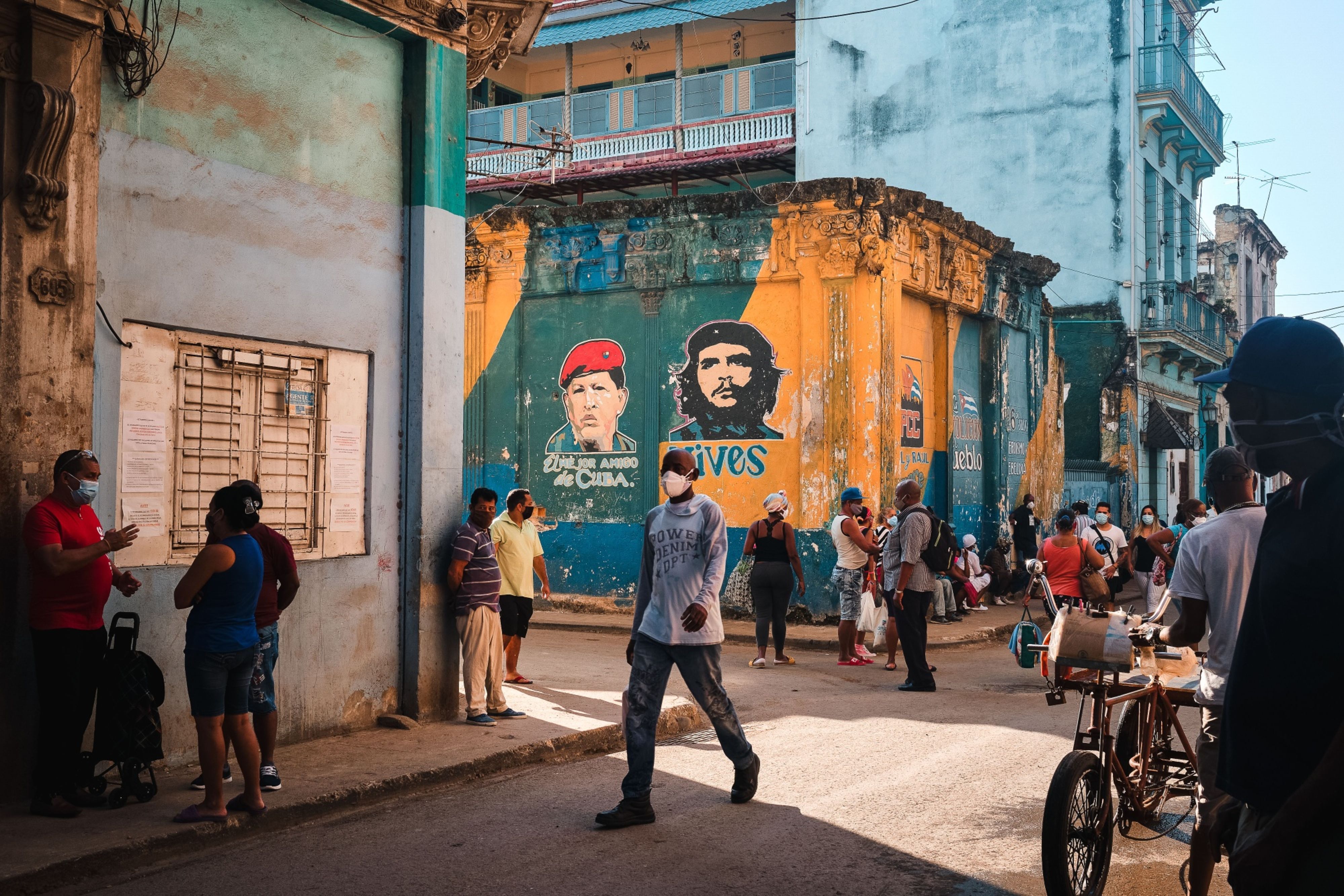 Customers wait in line to enter a grocery store in Havana, Cuba near portraits of the late revolutionary Ernesto ‘Che’ Guevara (right) and the late Venezuelan President Hugo Chavez