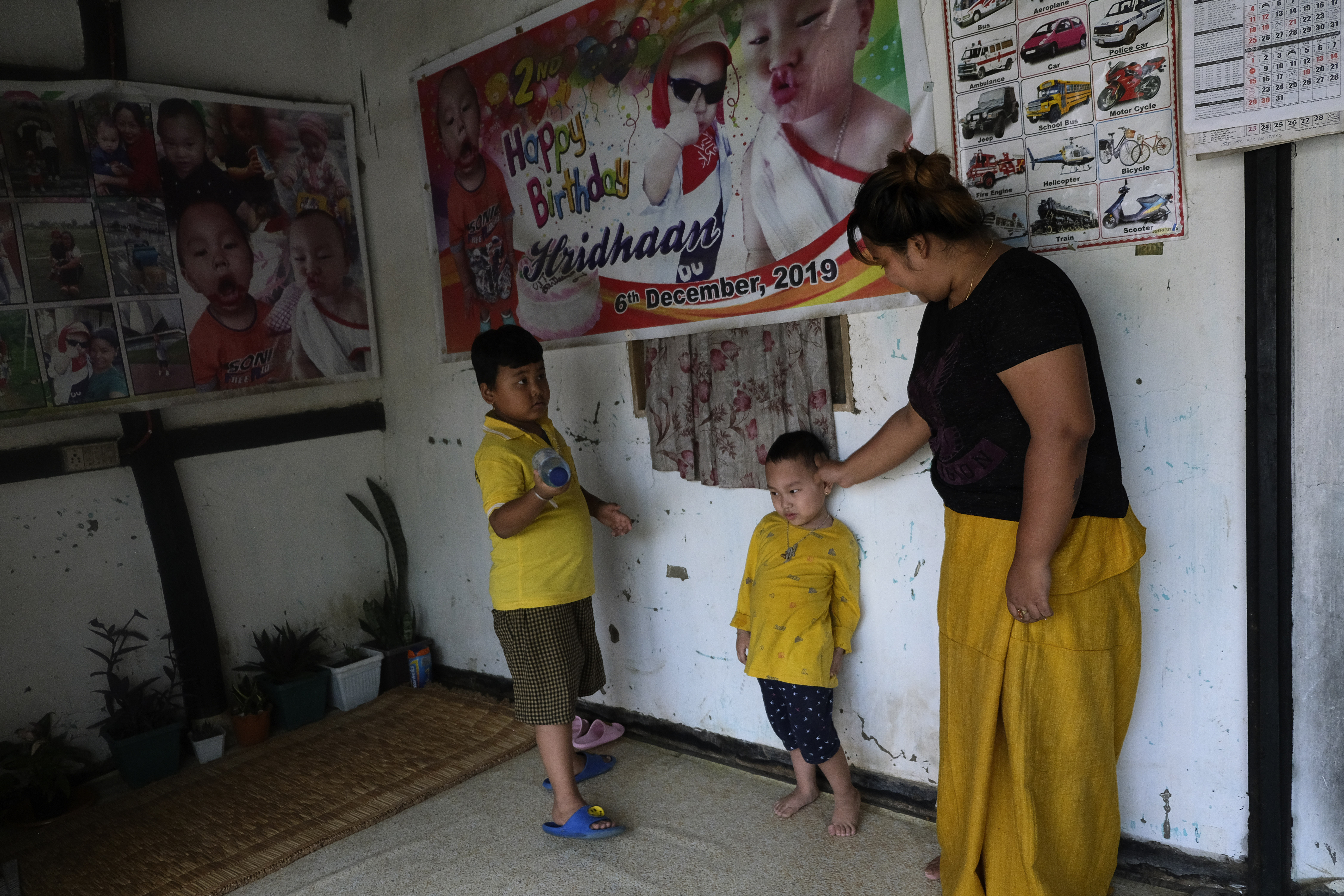 Khumanthem plays with her three-year-old nephew Hridhaan, (centre), who she has decided to raise as her own after his mother Ranjita died of COVID-19