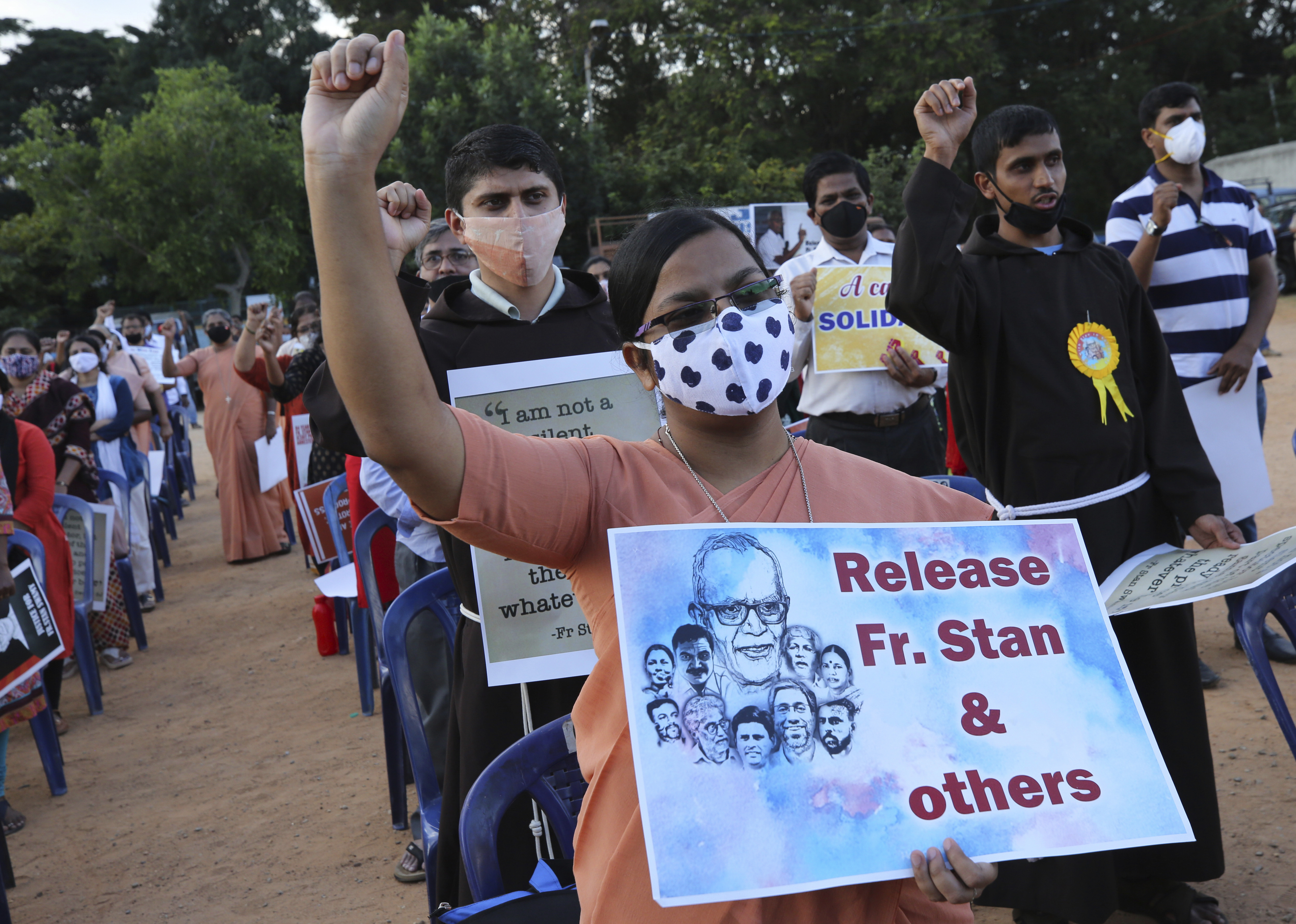 In this November 12, 2020 photo, a Christian nun, centre, holds a placard and shouts slogans with others demanding the release of Stan Swamy