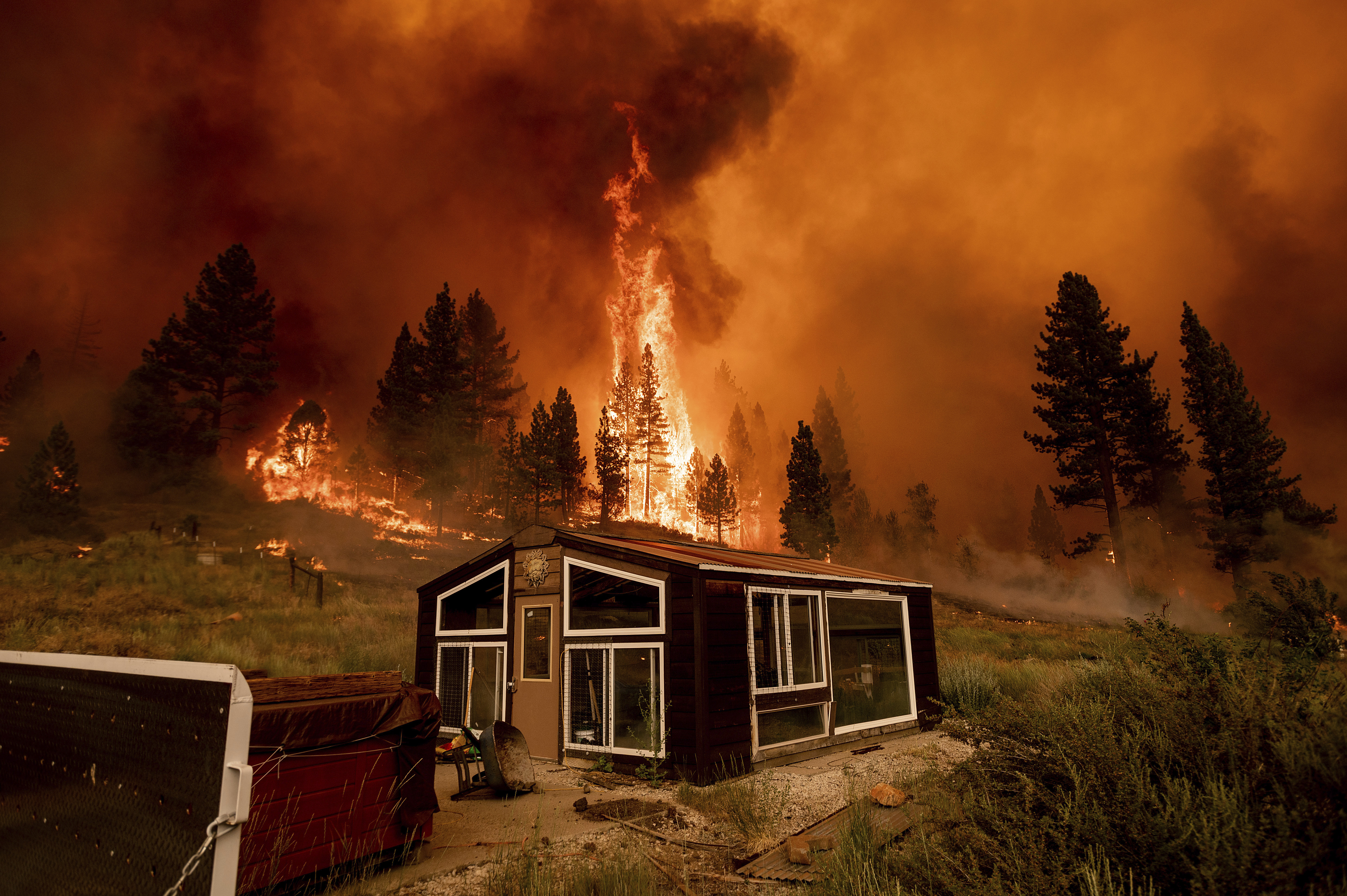 The Tamarack Fire burns behind a greenhouse in the Markleeville community of Alpine County, California, on July 17