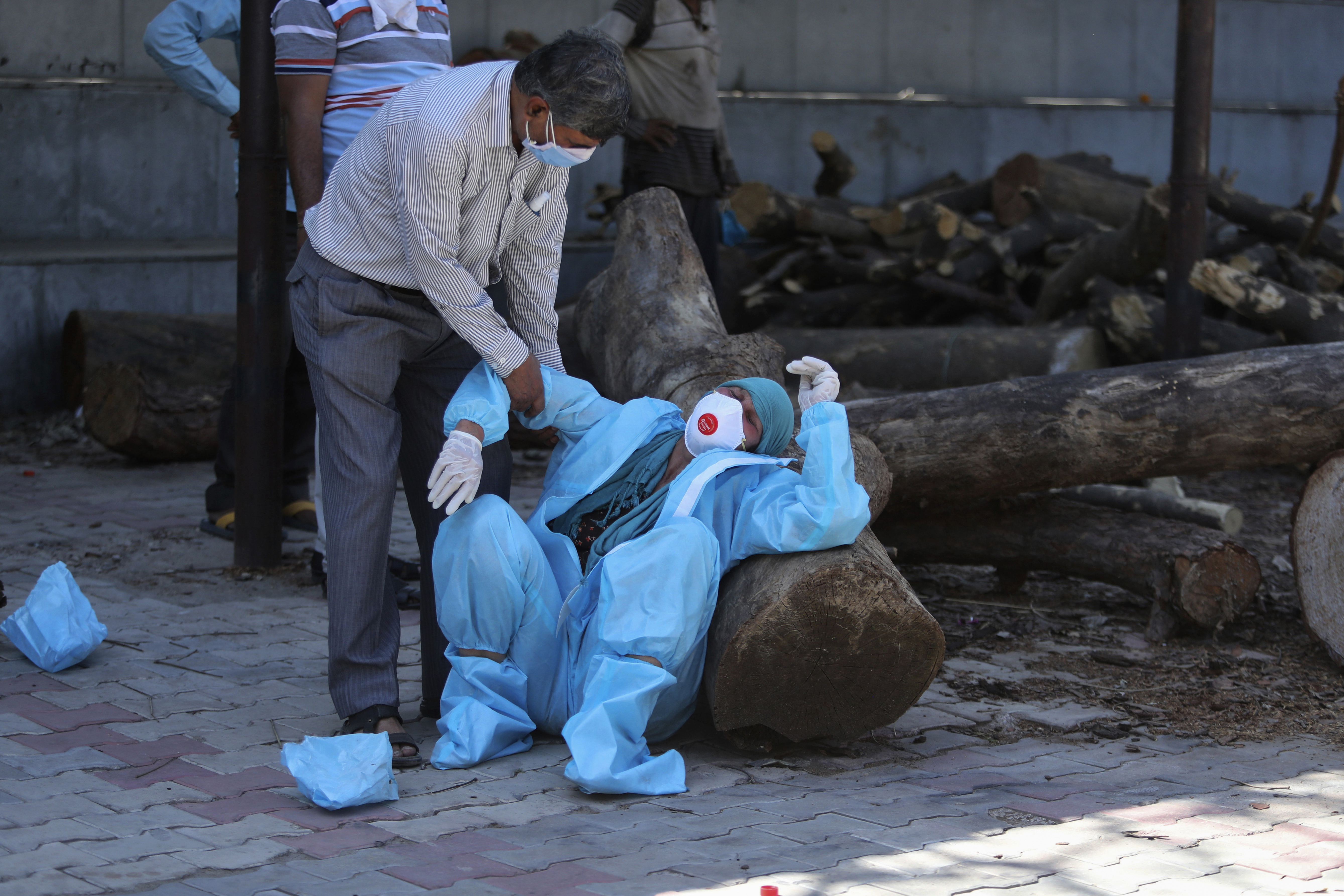In this April 25, 2021 photo, a relative of a person who died of COVID-19 breaks down during cremation in Jammu, Indian-administered Kashmir