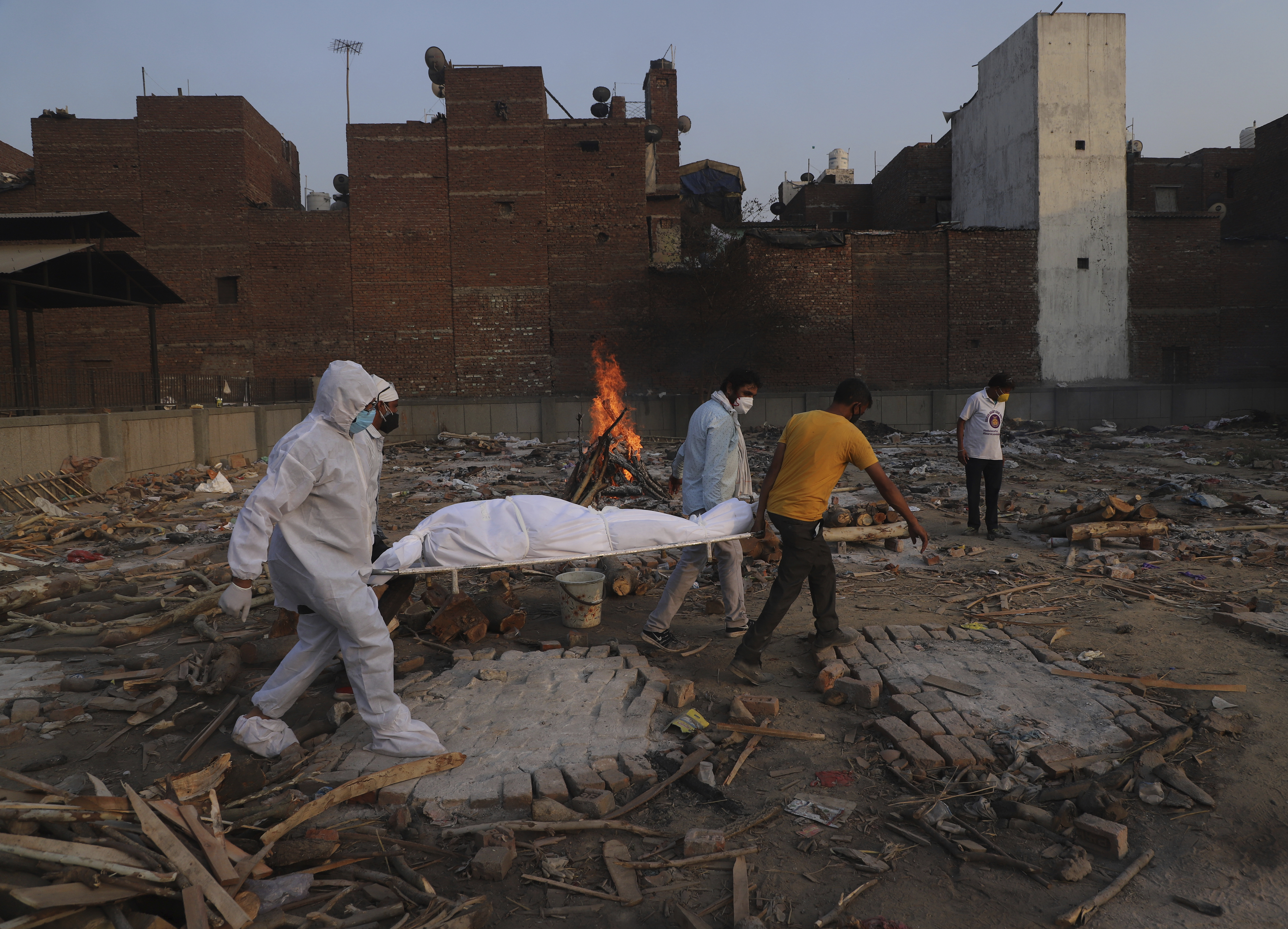 In this May 11, 2021 photo, family members and volunteers carry the body of a COVID-19 victim for cremation in New Delhi