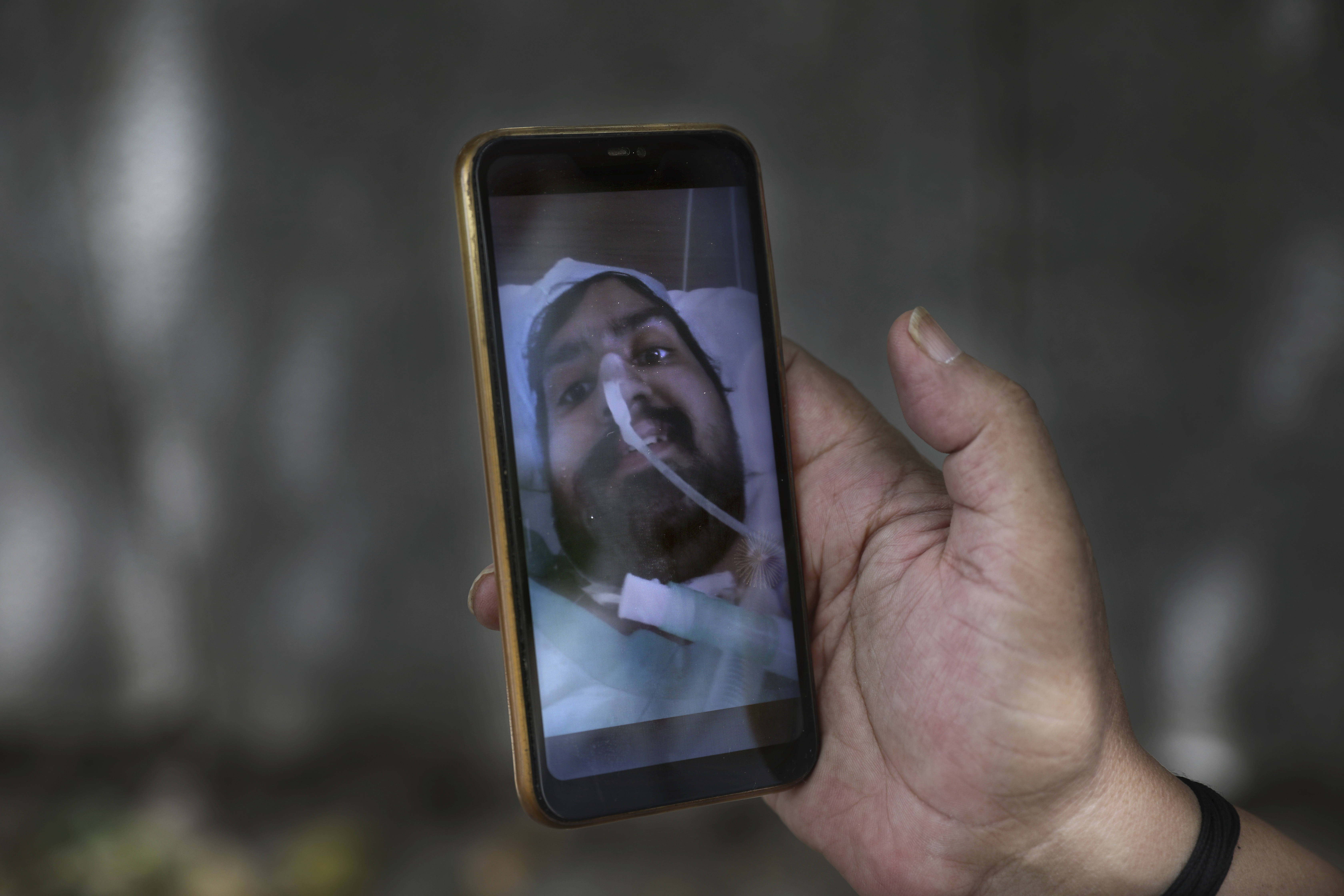 Anil Sharma shows a photograph of his son Saurav who is being treated for COVID-19 at a private hospital in New Delhi
