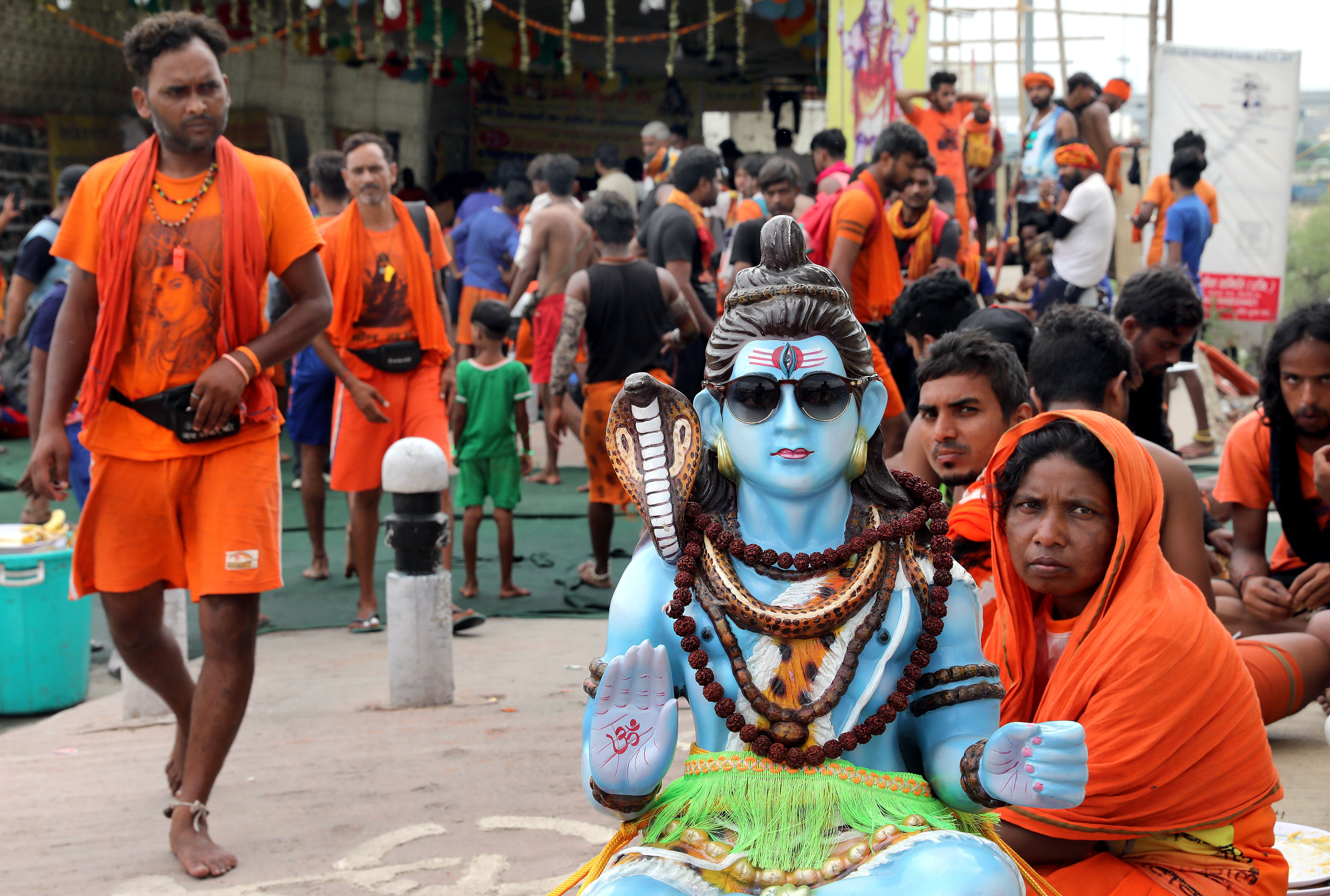 Pilgrims with an idol of Lord Shiva rest at a makeshift camp in New Delhi, India