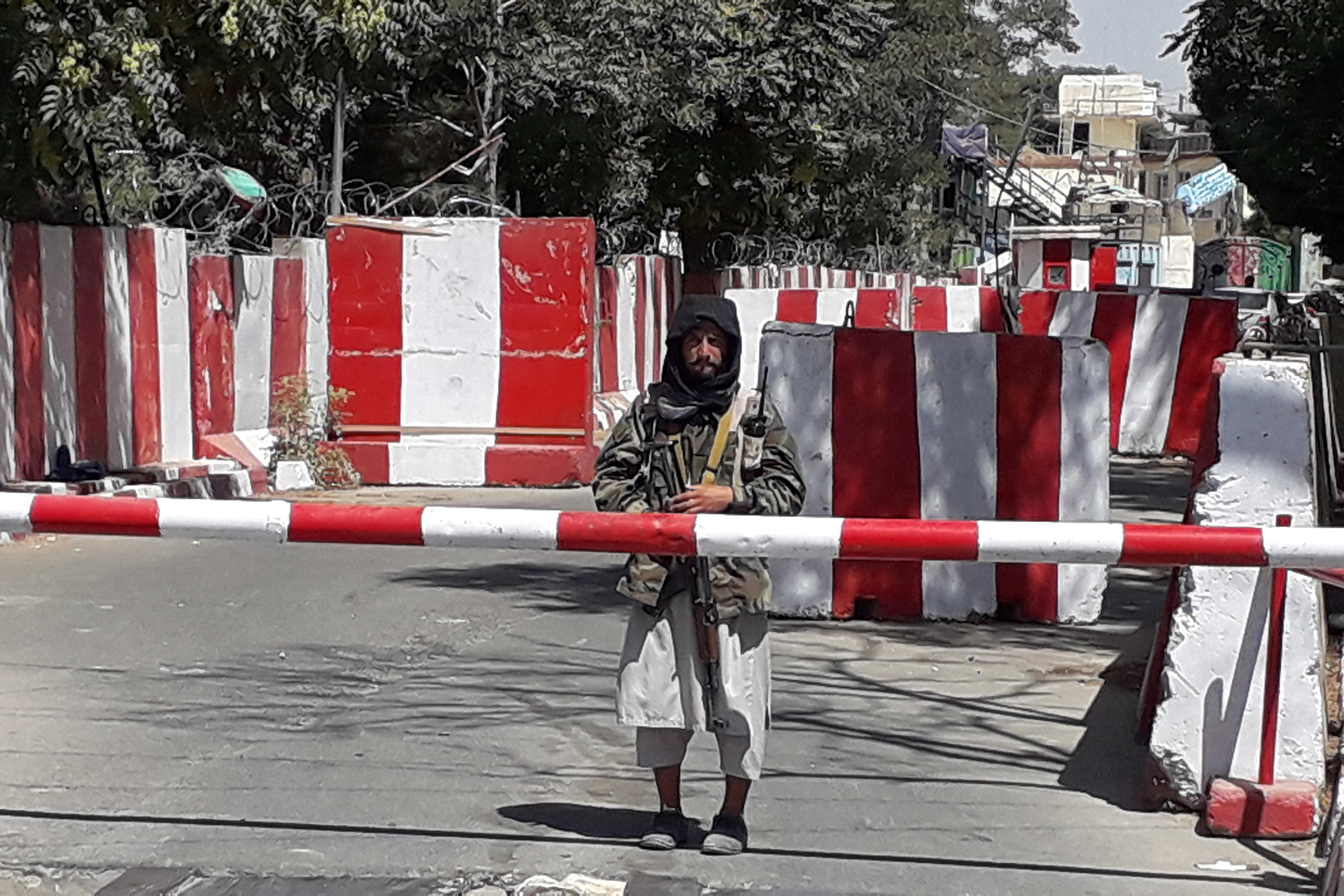 A Taliban fighter stands guard at the entrance of the police headquarters in Ghazni [AFP]