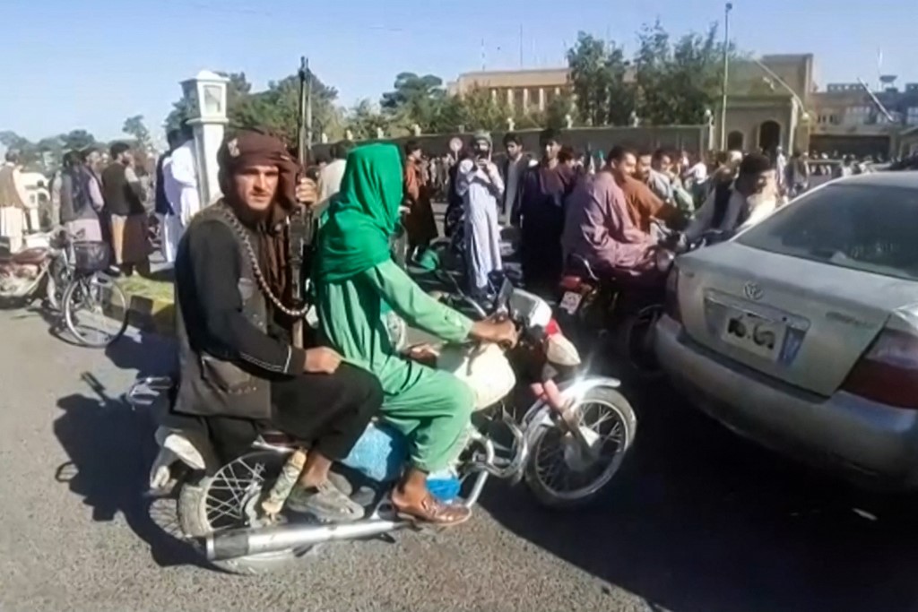 An armed member of the Taliban on the back of a motorbike in the streets of Herat